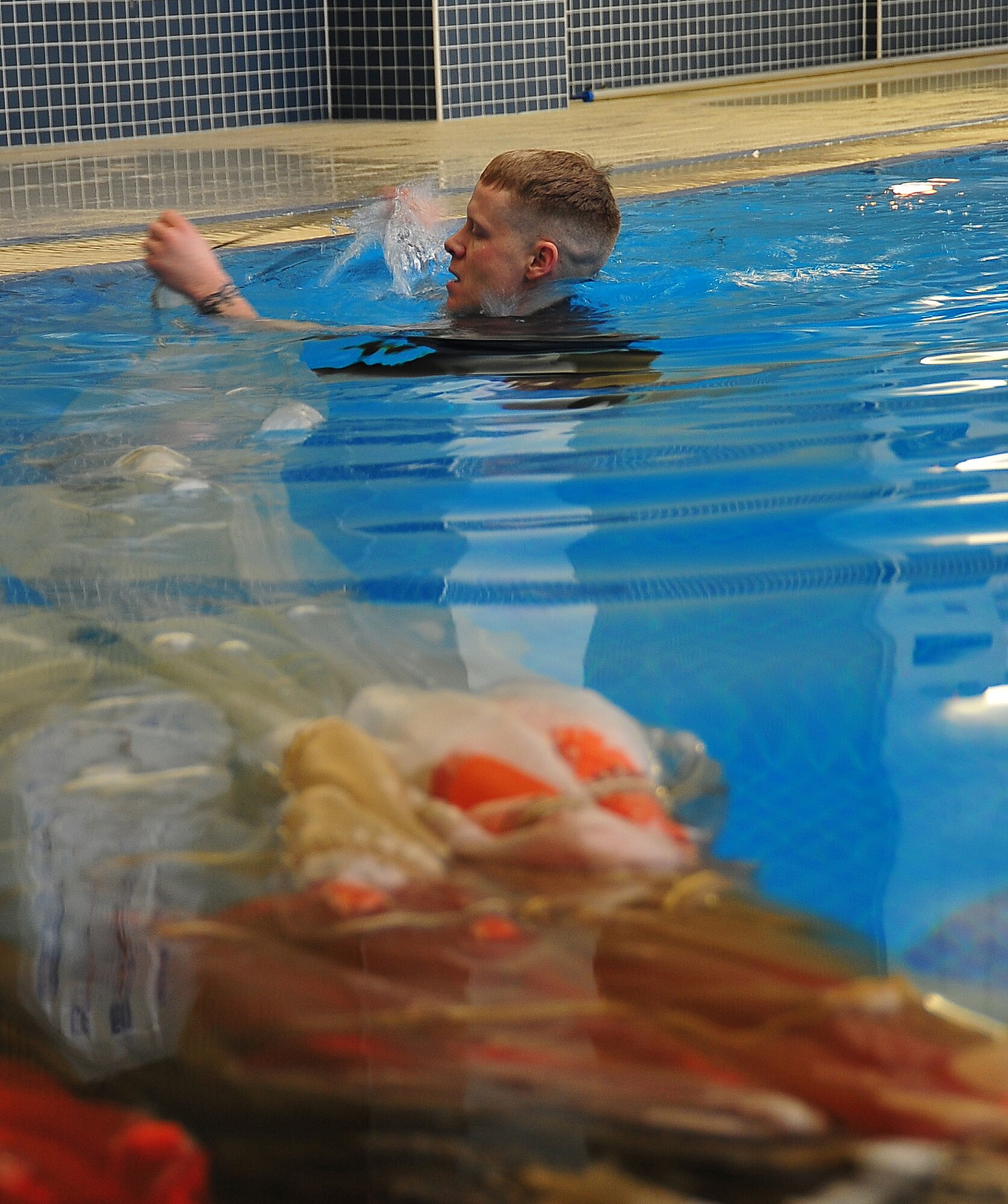 During operational readiness exercise Beverly Midnight 11-02,  Capt. Kyle Crosby, 36th Squadron pilot, completed his water survival training evaluation, Osan Air Base, Republic of Korea, March 14.  The evaluation consisted of one-on-one scenarios requiring a member to lift oneself into a one-person raft,  identify three points of air entry to inflate the sides of the raft, demonstrate a canap? disentanglement technique by following a parachute line under water that lead the pilot to a clear area, simulating the experience of being caught under a parachute while in the water, and the final task, being dragged by a pulley through the water mimicking the feeling of wind catching the canopy of the parachute and dragging the pilot through water.  (U.S. Air Force Photo By Staff Sgt. Daylena Gonzalez)