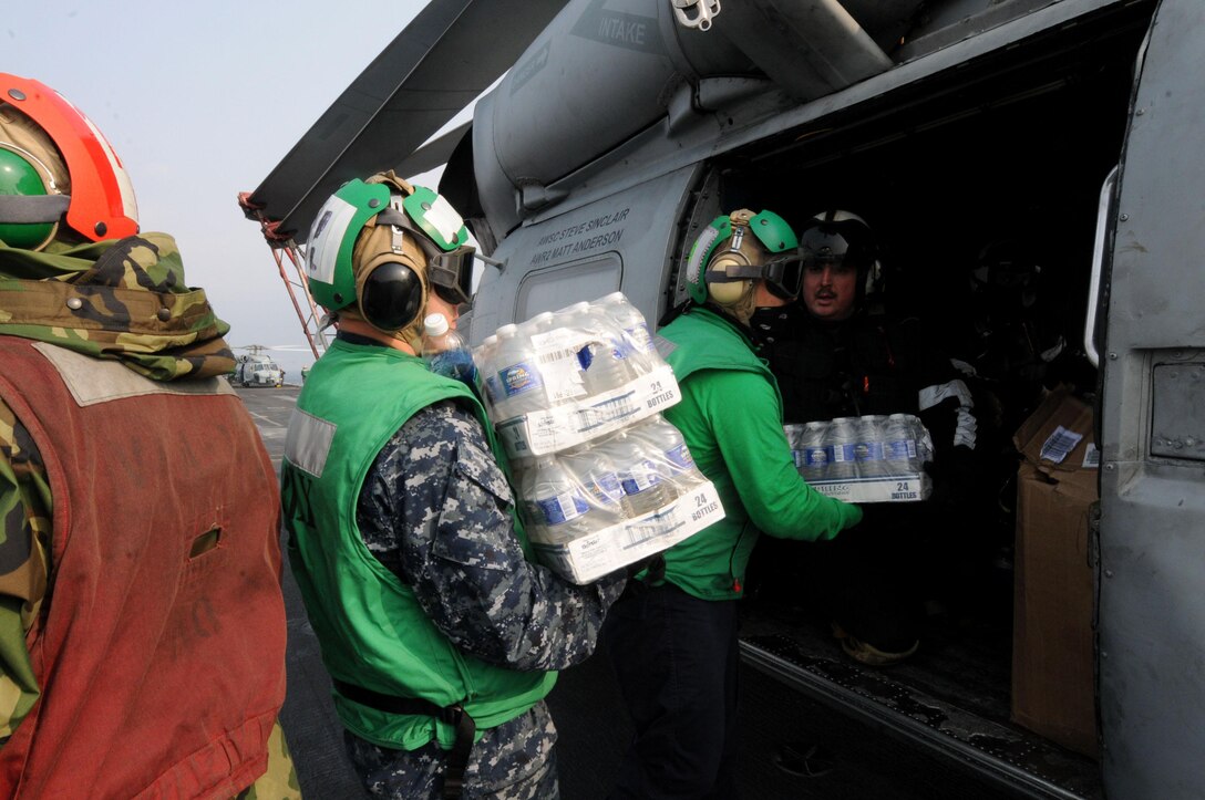 U.S. Navy sailors load supplies onto an HH-60H Seahawk helicopter aboard the aircraft carrier USS Ronald Reagan in the Pacific Ocean, March 14, 2011. The sailors are assigned to Anti-Submarine Squadron 4.