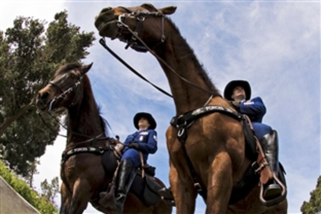 U.S. Air Force 1st Lt. Trayers and U.S. Air Force Staff Sgt. Lewis take a final ride with their horses, Judge and Willie, to their retirement ceremony on Vandenburg Air Force Base, Calif., March 14, 2011. Judge and Willie have faithfully served the Air Force at the base and in other parts of the world. Trayers and Lewis are members of the 30th Security Forces Squadron.