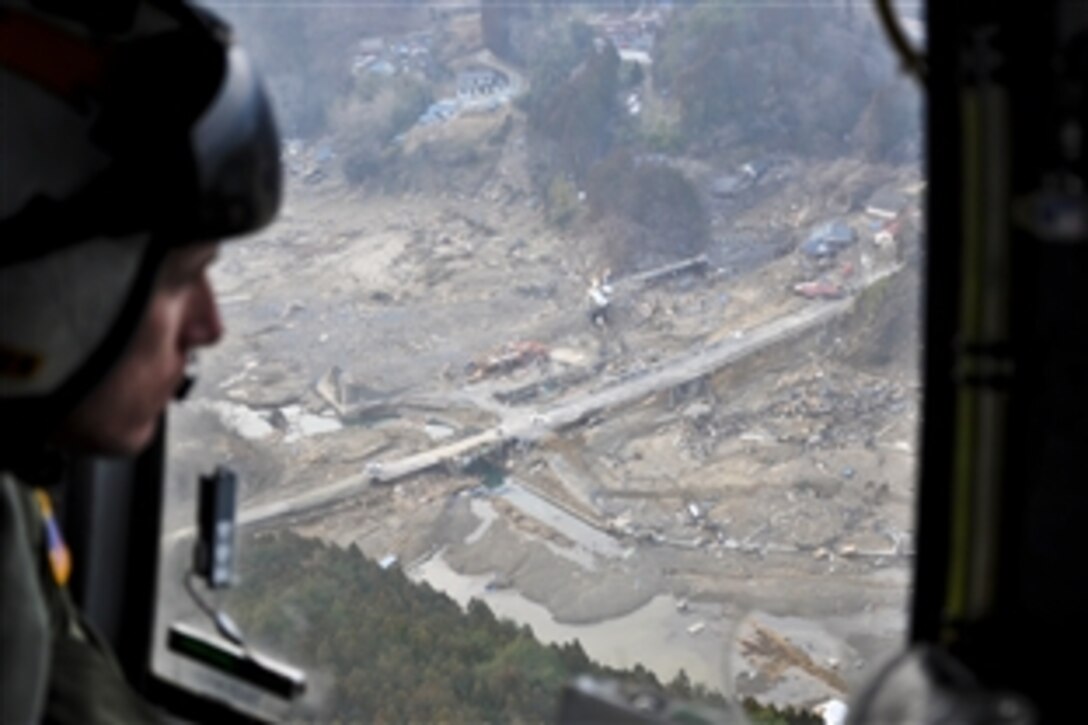 U.S. Navy Petty Officer 3rd Class Garrett Krygier surveys the destruction in Miyagi prefecture, Japan, March 14, 2011, from an 8.9-magnitude earthquake and tsunami that struck northern Japan. Krygier is an aircrewman assigned to Helicopter Anti-Submarine Squadron 14, based on Naval Air Facility Atsugi, Tomodachi. 