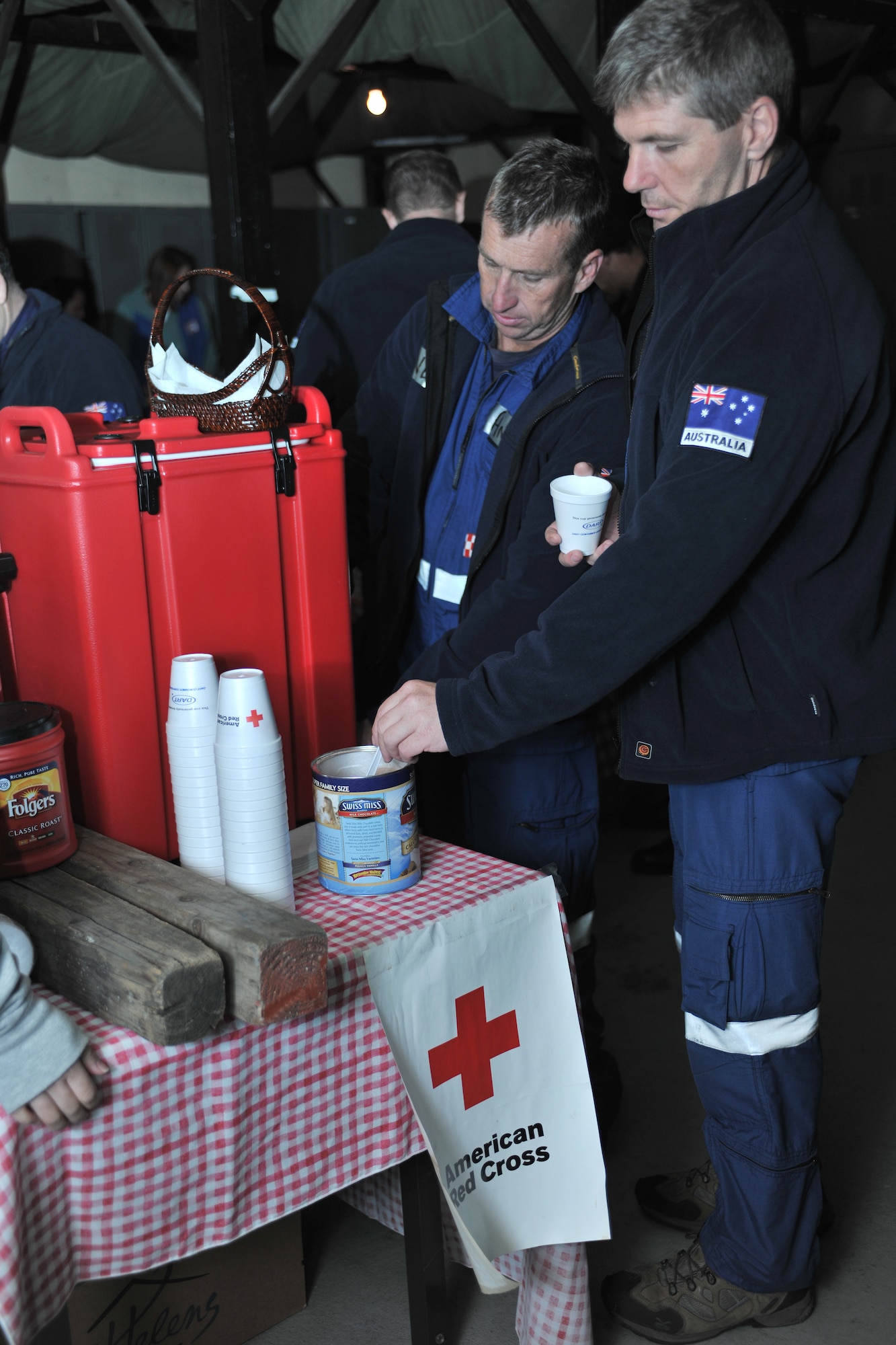 YOKOTA AIR BASE, Japan -- Members of the Queenland Urban Search and Rescue Taskforce partake in the refreshments provided by the American Red Cross here March 14. The Red Cross volunteers operate a canteen 24-hours a day for inbound relief forces. (U.S. Air Force photo/Master Sgt. Kimberly Spinner) 
 
