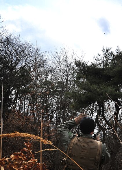 Capt. Miles Newsome, a 25th Fighter Squadron pilot, uses a mirror from his survival kit to make contact with an aircraft during a combat search and rescue scenario in Jeugaun, Republic of Korea, March 16. The evaluation tested Captain Newsome's survival techniques such as gathering all evidence of his landing and concealing it with nearby brush. Then the captain also communicated with an A-10 providing cover for rescue efforts. (U.S Air Force photo/Staff Sgt. Daylena Gonzalez)