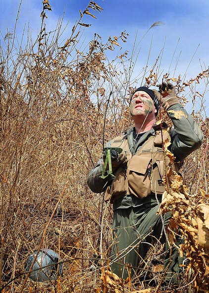 Capt. Miles Newsome, a 25th Fighter Squadron pilot, uses a mirror from his survival kit to make contact with an aircraft during a combat search and rescue scenario in Jeugaun, Republic of Korea, March 16. The evaluation tested Captain Newsome's survival techniques such as gathering all evidence of his landing and concealing it with nearby brush. Then the captain also communicated with an A-10 providing cover for rescue efforts. (U.S Air Force photo/Staff Sgt. Daylena Gonzalez)