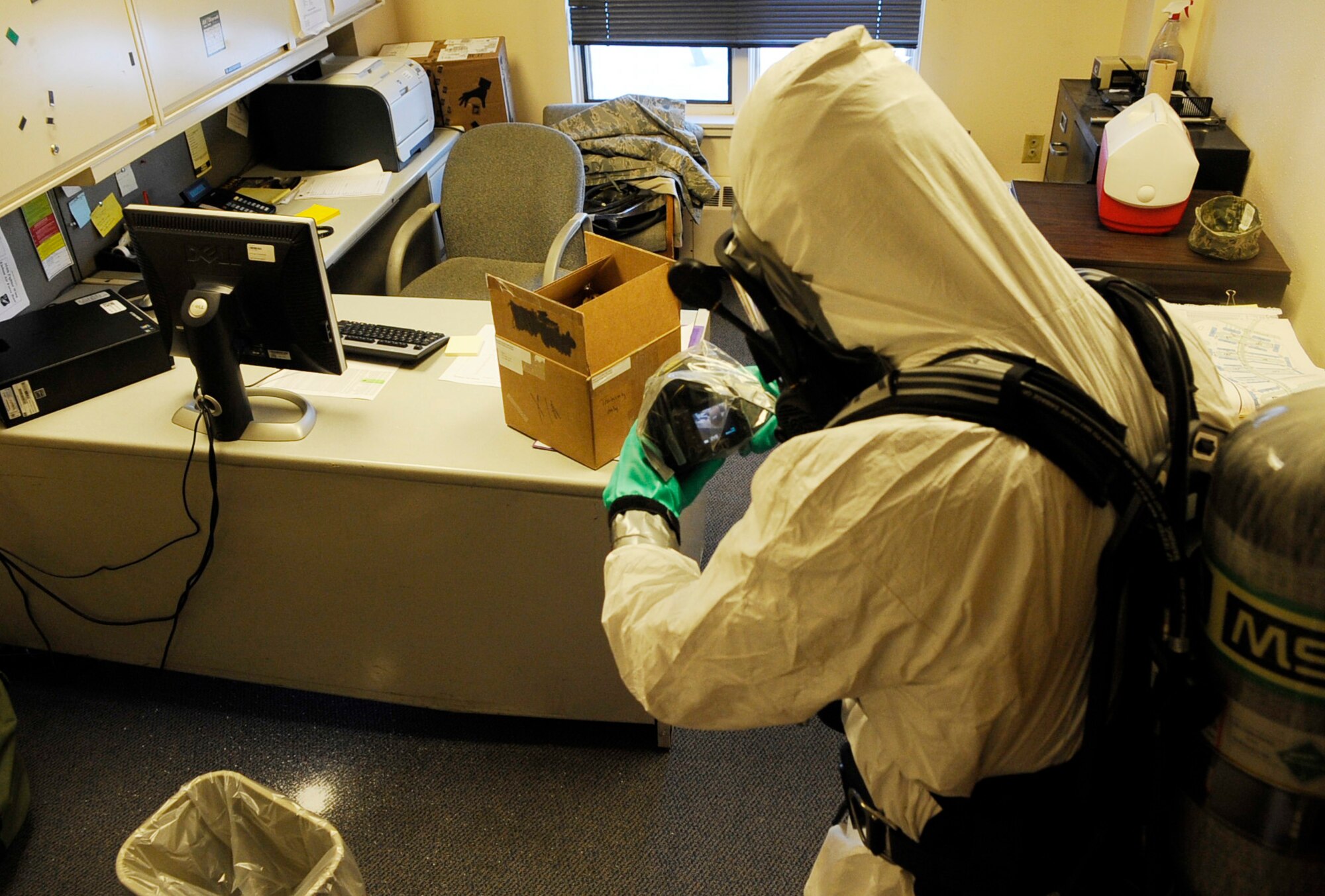 Senior Airman Donny Baker photographs a simulated suspicious powder during an operational readiness exercise March 11, 2011, Eielson Air Force Base, Alaska. Responders were required to wear personal protective equipment to simulate a real-world chemical threat. Airman Baker is a bio-environmental technician assigned to the 354th Medical Operations Squadron. (U.S. Air Force photo/Airman 1st Class Laura Goodgame)