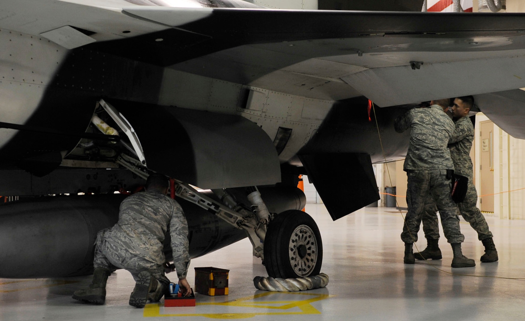 A weapons load crew works together to load munitions and flares onto an F-16 Fighting Falcon during the annual load crew of the year competition March 11, 2011, Eielson Air Force Base, Alaska. The competition is a challenge between the top two weapons crews with the best year long statistics. The Airmen are assigned the 354th Aircraft Maintenance Squadron.   (U.S. Air Force photo/Airman 1st Class Laura Goodgame)
