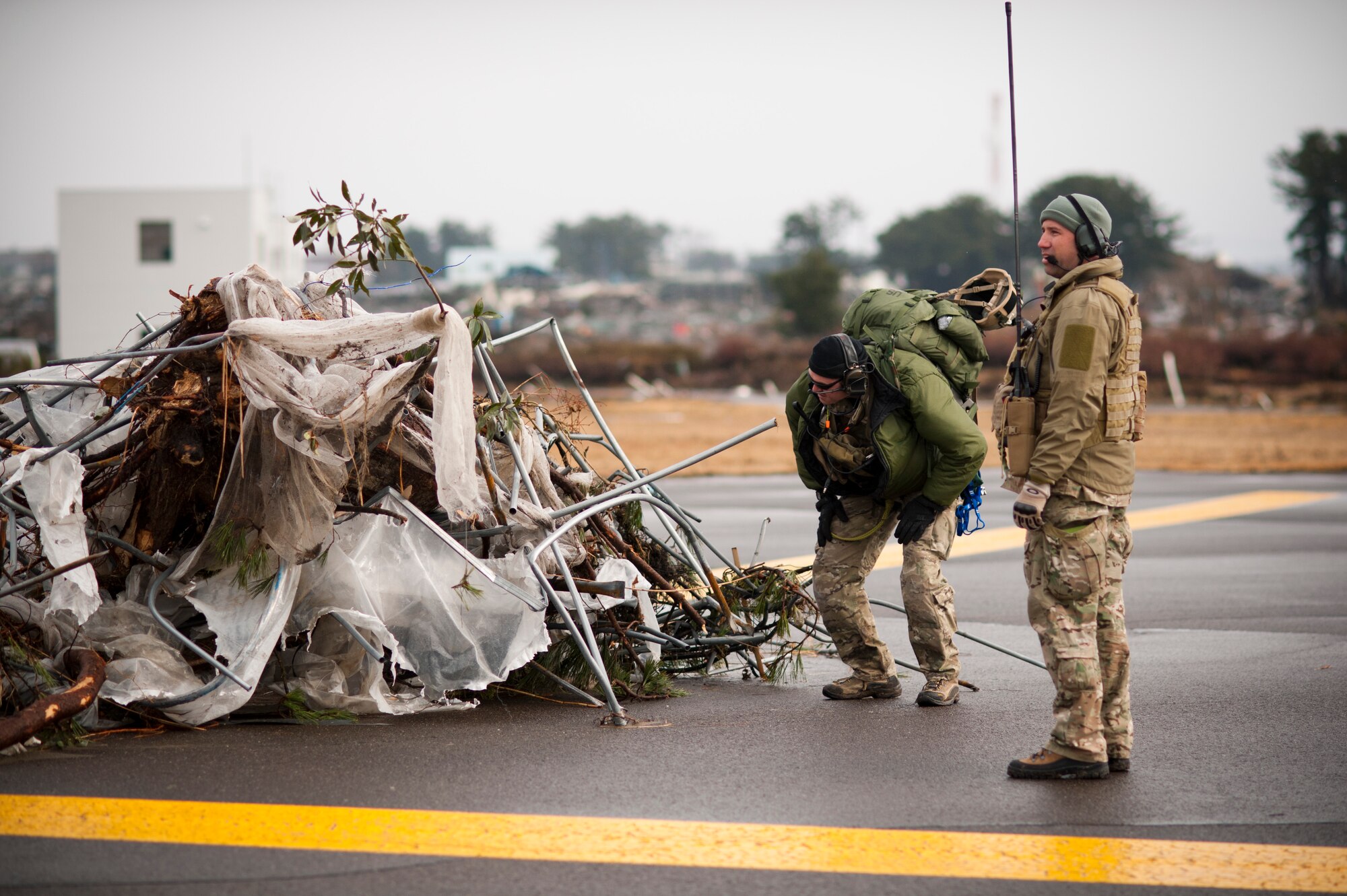 SENDAI AIRPORT, Japan -- Airmen from the 320th Special Tactics Squadron assess debris on the runway here March 16. Members of the 320th STS, stationed out of Kadena Air Base, deployed to Sendai Airport to help clear the runway and make it ready for fixed-wing aircraft traffic. (U.S. Air Force photo / Staff Sgt. Samuel Morse)