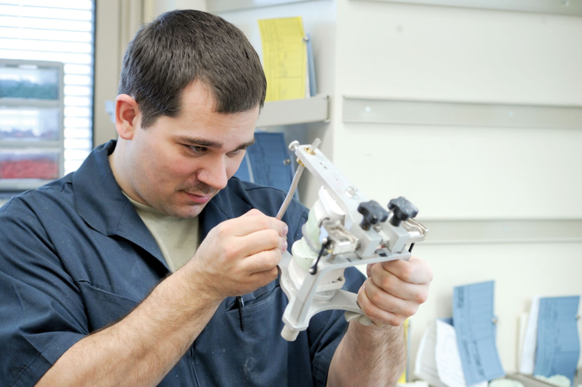 Senior Airman Robert Thompson, a lab technician with the 673d Dental Squadron, uses a articulator to check the occlusion between the upper and lower mouth to ensure that a tooth being fabricated is of correct height in correlation to the other teeth. (U.S. Air Force photo/Staff Sgt. Joshua Garcia)