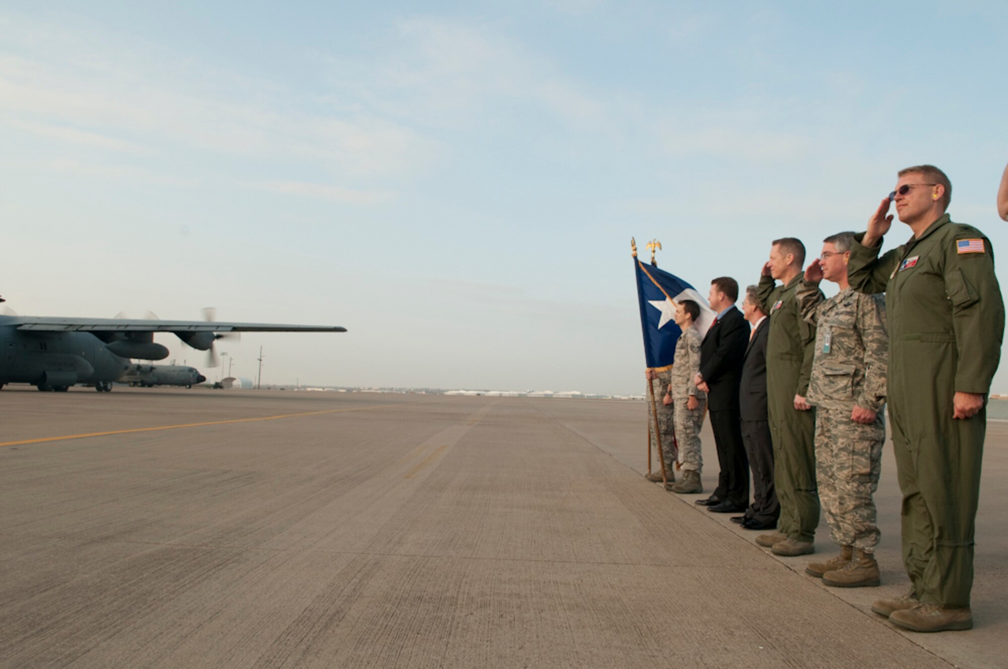 Members of the 136th Airlift Wing along with Mr. John Wood, North Texas Regional Director for Senator John Cornyn and Mr. Charles Boswell, representing State Senator Wendy Davis give honor to those deploying in support of Operation Enduring Freedom aboard the C-130H from the wing. The deployers will be supporting the 774th Expeditionary Airlift Squadron in both air and ground operations. (U.S. Air Force photo by Senior Master Sgt. Elizabeth Gilbert/released)