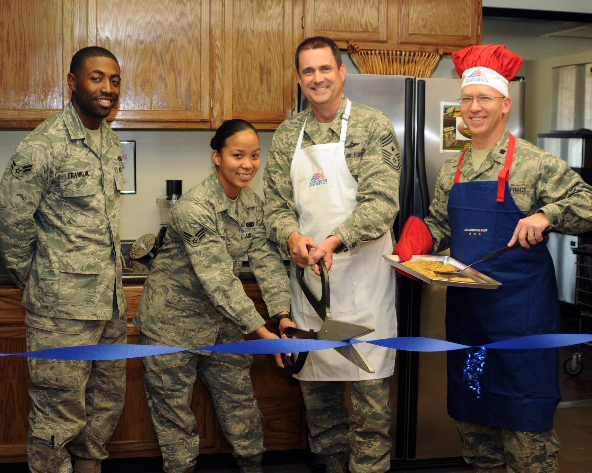 ALTUS AIR FORCE BASE, Okla. -- (L to R) Airman 1st Class Bryan R. Franklin and Senior Airman Angelic A. Ancho, Dorm 331 residents, Chief Master Sgt. Bob Austin, 97th Air Mobility Wing command chief, and Lt. Col. David S. Vaughn, 97th Mission Support Group deputy commander, cut the ribbon to the newly renovated kitchen at dorm 331 here March 16. The kitchen renovation was a $30,000 project and took six weeks to complete. The work was done by the 97th Civil Engineer Squadron's facilities improvement steering team. (U.S. Air Force photo by Airman 1st Class Kenneth W. Norman/ released 97th Air Mobility Wing Public Affairs)