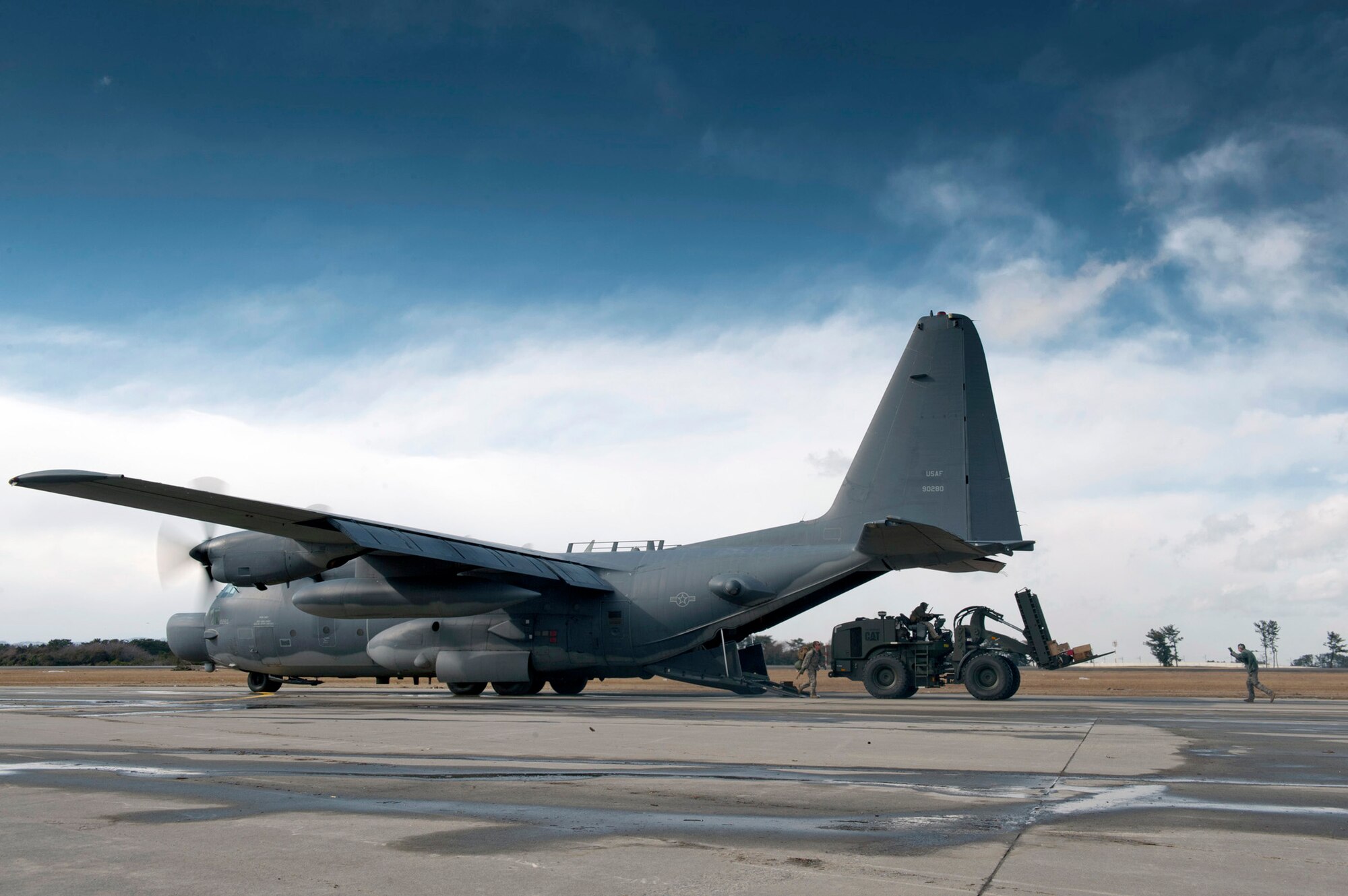 Airmen unload supplies and a forklift from a MC-130H Combat Talon II, at Sendai Airport, Japan on March 16, 2011. This is the first fixed-wing aircraft to land at the airport since an earthquake and tsunami crippled much of the Japanese eastern seaboard March 11. The opening of this runway to fixed-wing aircraft by the 320th Special Tactics Squadron and Japanese emergency management organizations provides a critical means of transporting fuel, equipment, food and other supplies to areas affected by the earthquake and tsunami. (U.S. Air Force photo by Staff Sgt. Samuel Morse)