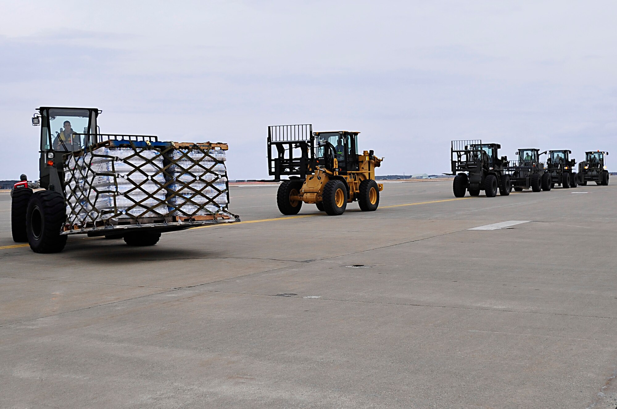 A forklift off-loads a pallet of water March 15, 2011, from a C-17 Globemaster III that has landed at Misawa Air Base, Japan. Airmen from the 35th Logistics Readiness Squadron preposition forklifts and other cargo-handling equipment to rapidly and efficiently off-load humanitarian relief supplies from arriving aircraft. (U.S. Air Force photo/Staff Sgt. Marie Brown)