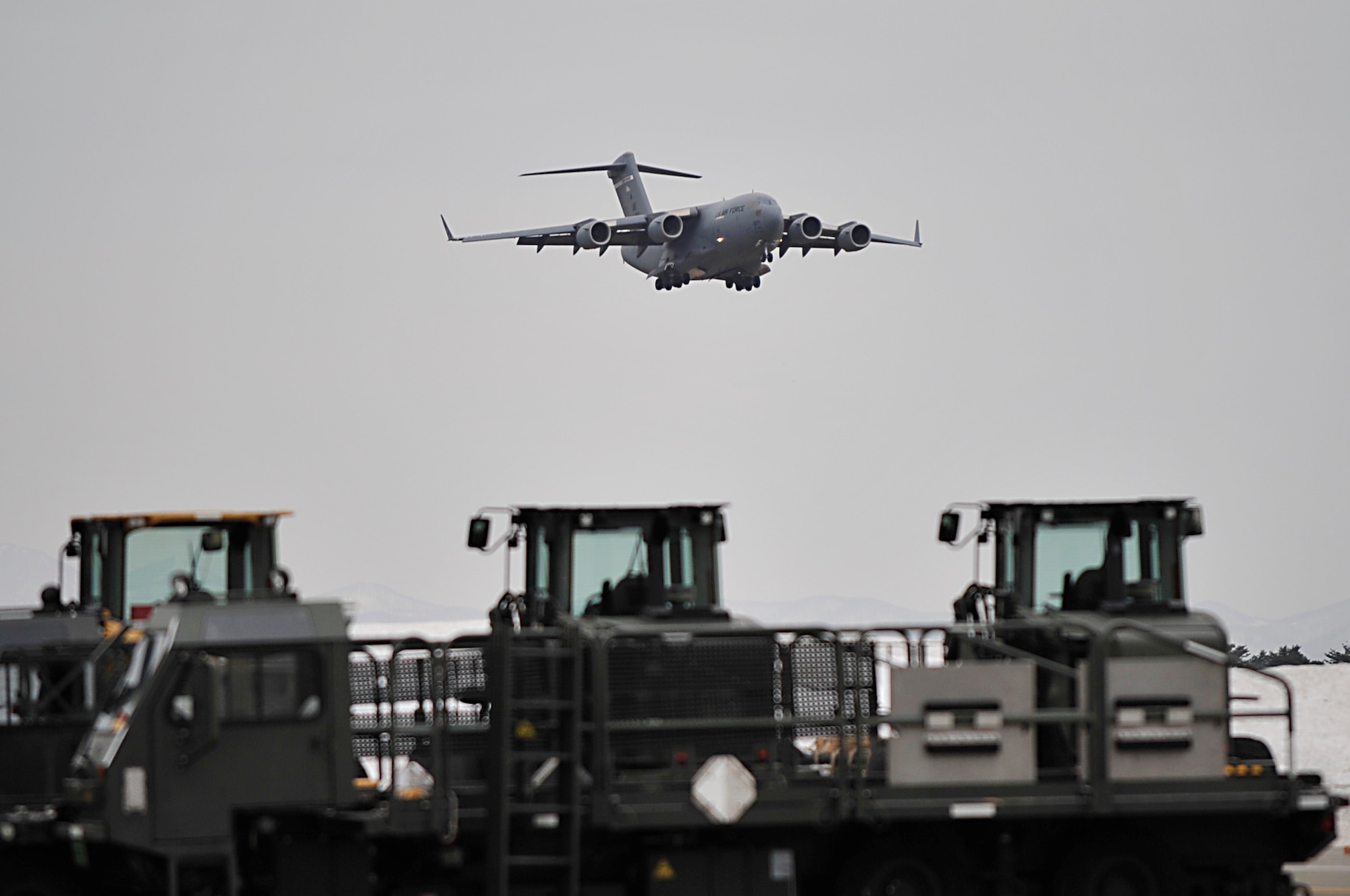 A C-17 Globemaster III comes in for a landing March 15, 2011, at Misawa Air Base, Japan. Airmen from the 35th Logistics Readiness Squadron stand by with forklifts and other cargo-handling equipment to off-load humanitarian relief supplies.  (U.S. Air Force photo/Staff Sgt. Marie Brown)