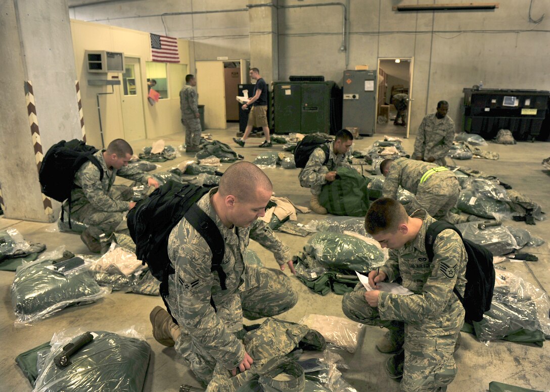 Members of the 18th Civil Engineer Group go over check list and prepare mobility bags to head north to Misawa Air Base, here at Kadena Air Base, March 12. 18th CEG members will assist Misawa personnel with regaining the electronic and power capabilities. (U.S. Air Force photo/ Staff Sgt. Lakisha A.Croley)