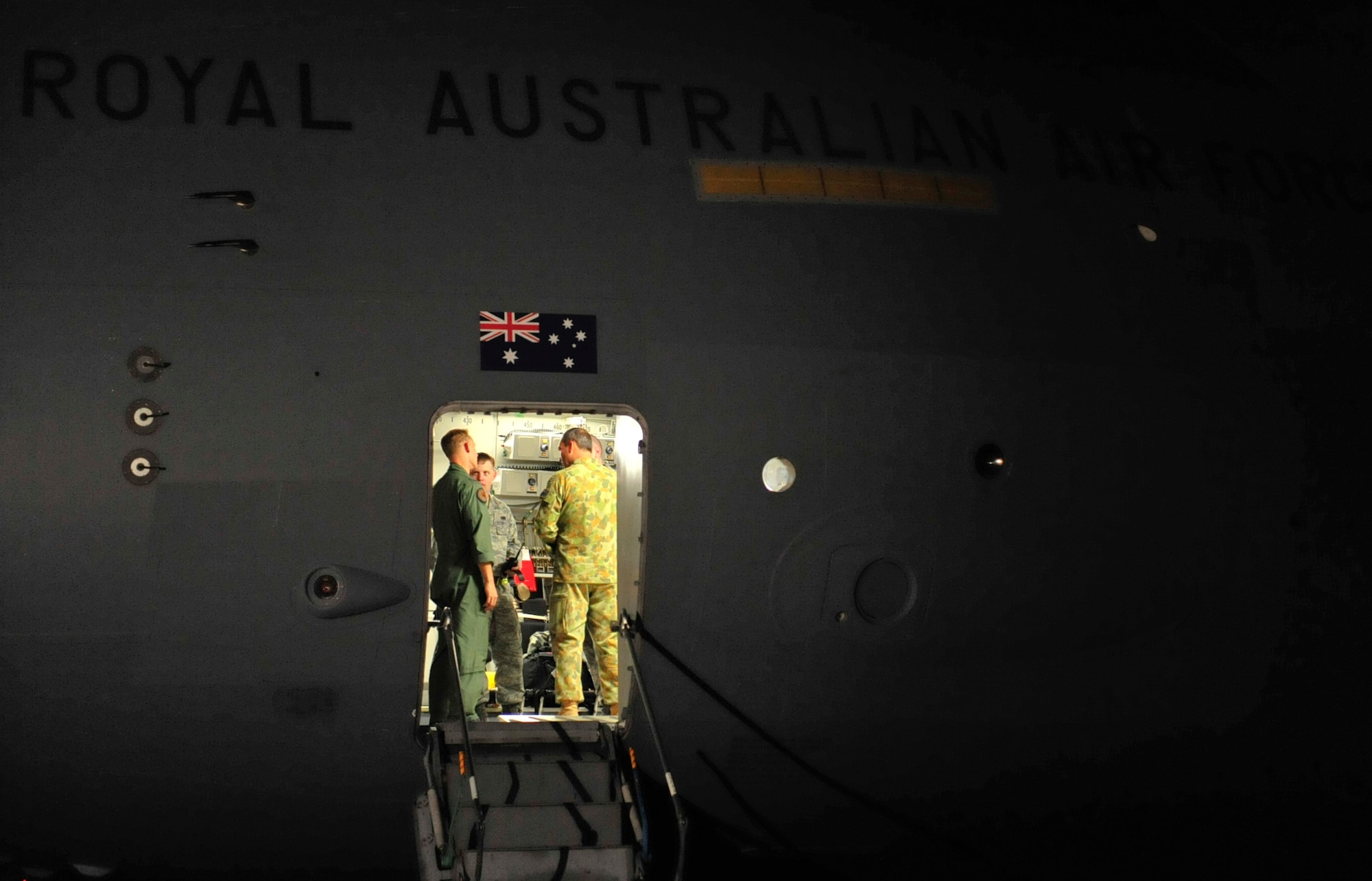 Kadena Airmen and Members of the Royal Australian Air Force discuss their upcoming mission inside the RAAF C-17 Globemaster III before heading to northern Japan March 17.  The C-17, along with several members of the RAAF came to Kadena to load supplies and a team from the Japan Self Defense Force and then transport them to northern Japan in support of earthquake and tsunami relief efforts. (U.S. Air Force photo/Senior Airman Sara Csurilla)