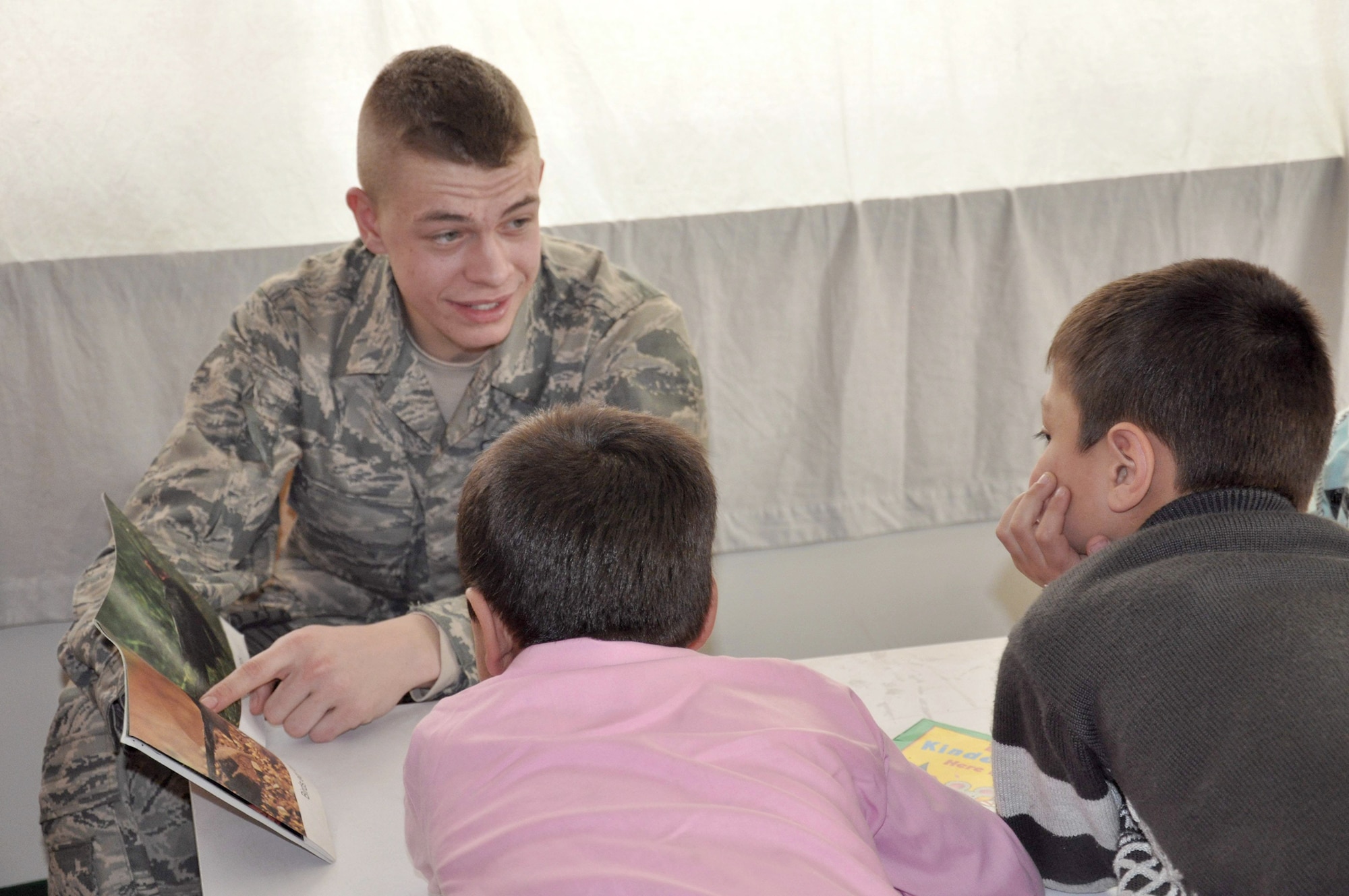Airman Nicholas Johnson reads a book to children during a community outreach event March 15, 2011, at a school in Kabul, Afghanistan. Airman Johnson is a patrolman assigned to the NATO Training Mission-Afghanistan. NTM-A members have hosted the reading program for the last six months and servicemembers from different nations have participated in the program every few weeks. (U.S. Air Force photo by Tech. Sgt. April Lapetoda)

