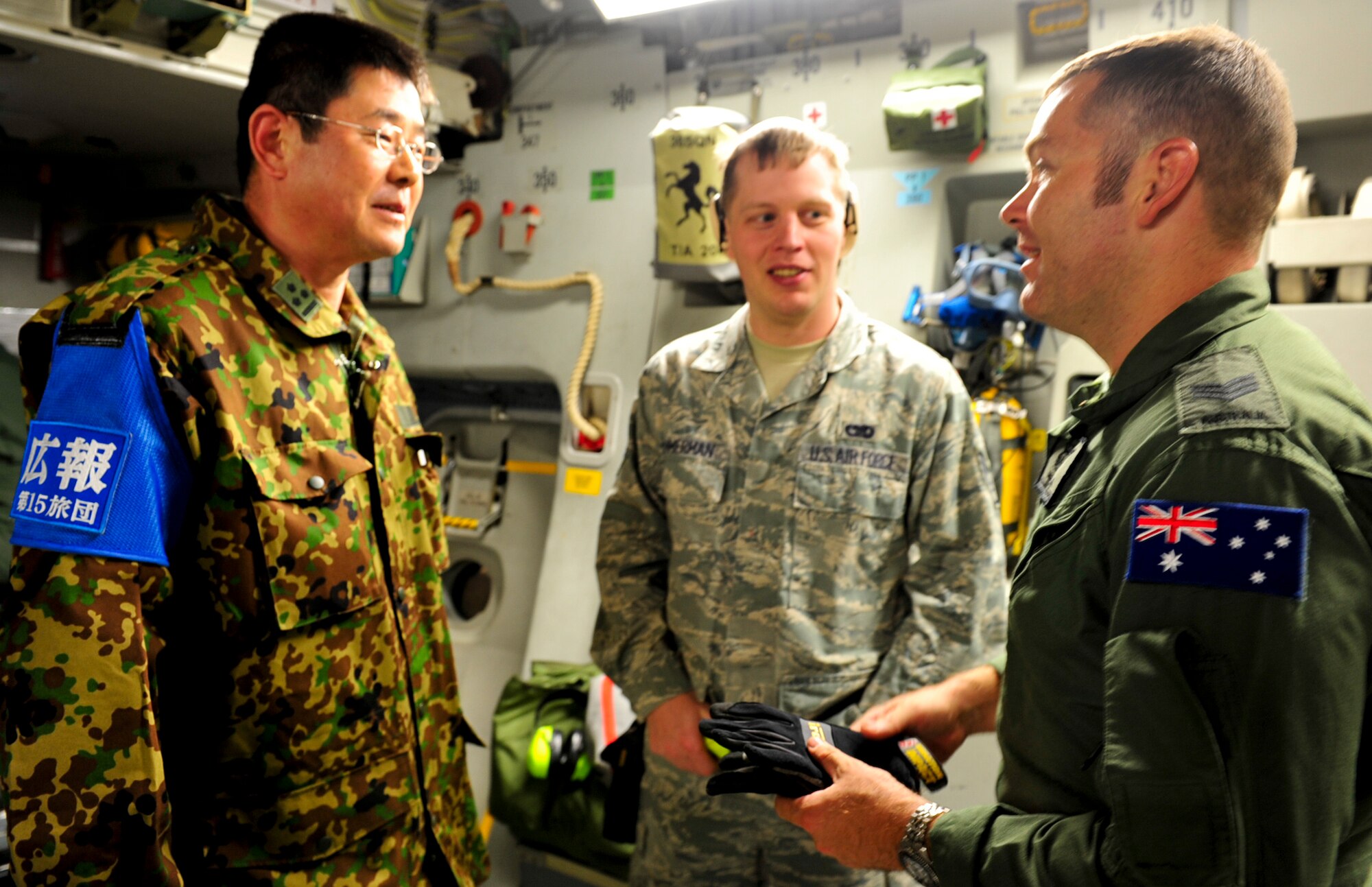 Senior Airman Andrew Ammerman, an Air Terminal Operations Center controller with the 733rd Air Mobility Squadron, Sgt. Derek Long, a loadmaster with the Royal Australian Air Force and Capt. Hirofumi Shimoda, the chief of Public Affairs with the 15 Brigade, Japan Ground Self Defense Force, greet each other after a Royal Australian Aircraft landed at Kadena March 16. The Aircraft came to Kadena to load supplies and a team from the JGSDF and then transport them to northern Japan in support of earthquake and tsunami relief efforts. “We couldn’t say no to the opportunity to help our allies when faced with such a terrible tragedy,” said Wing Commander Sonja Hallorran, RAAF. (U.S. Air Force photo/Senior Airman Sara Csurilla)