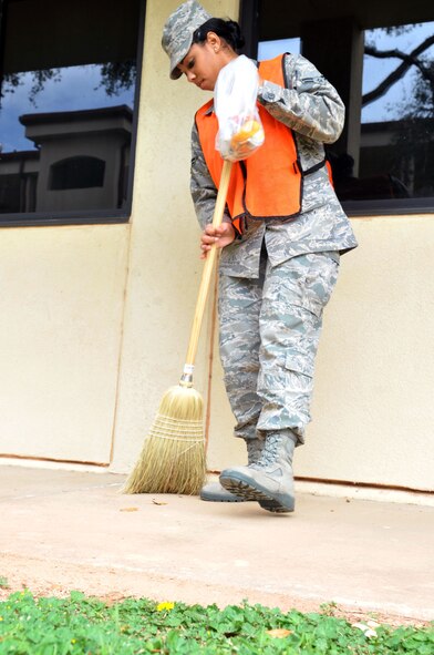 Airman 1st Class Ismary Gala Garcia, 2nd Force Support Squadron evaluation specialist, sweeps outside the dormitories during bay orderly at Barksdale Air Force Base, La., March 16, 2011. The bay orderly program requires dorm residents to help keep the base dormitories clean for Airmen.  (U.S. Air Force photo/Senior Airman Brittany Y. Bateman)