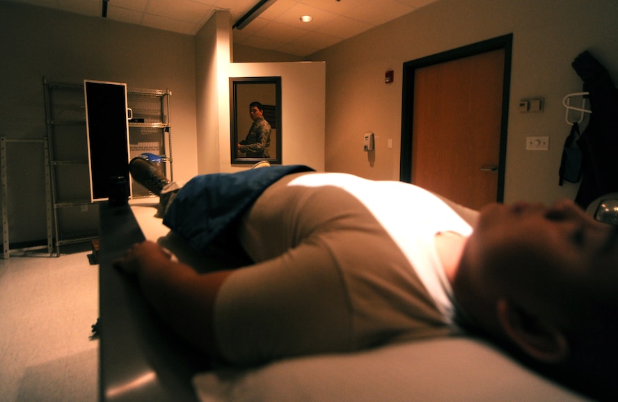 MOODY AIR FORCE BASE, Ga.-- Senior Airman Chris Kingsbury, 23rd Medical Group diagnostic imaging, starts the diagnostic imagery process March 16. The technician stands behind a wall to eliminate unwanted exposure to radiation.  (U. S. Air Force photo/Airman 1st Class Benjamin Wiseman)(RELEASED)