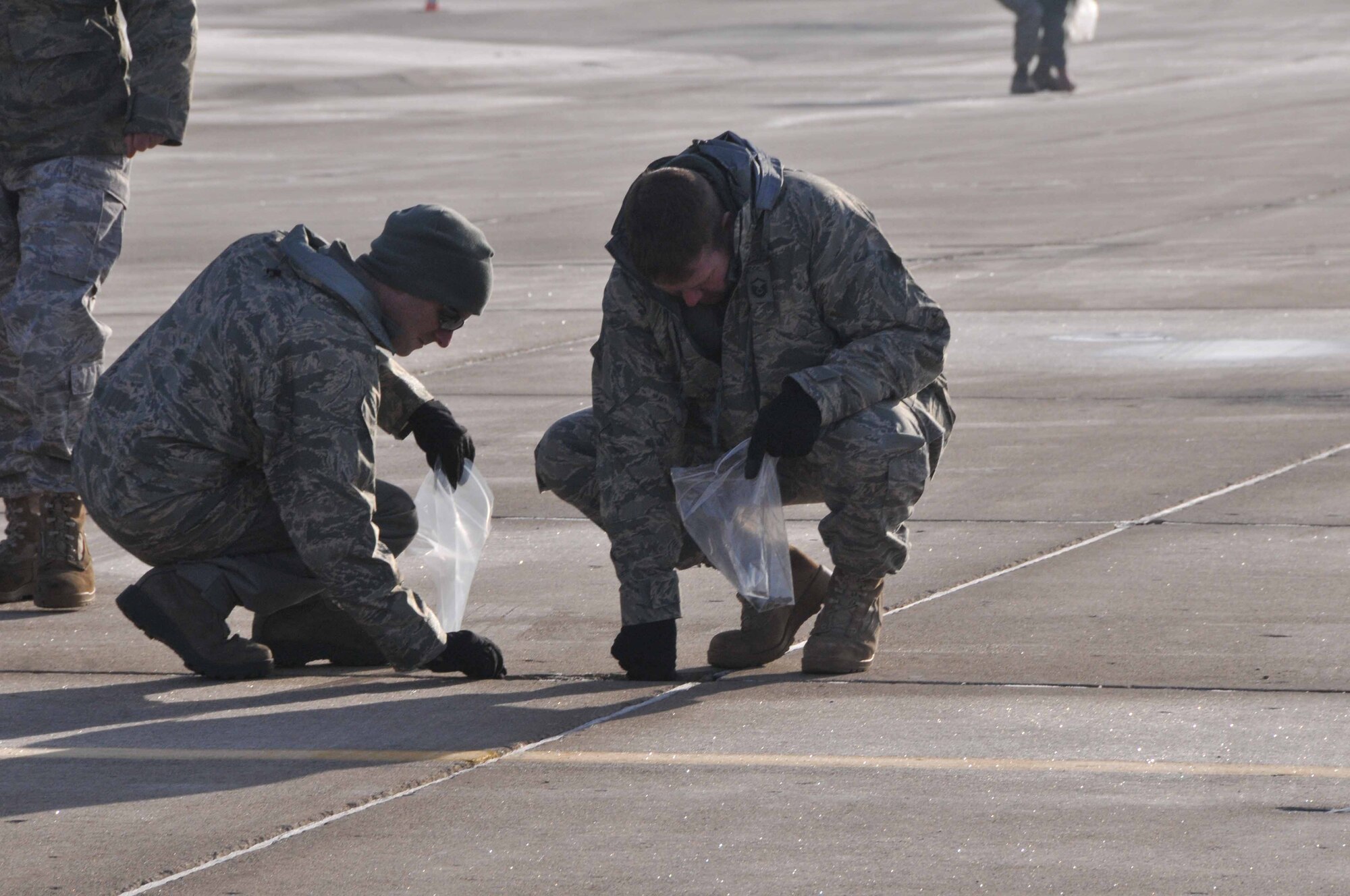 934th Airlift Wing members perform a Foreign Object Damage walk March 16 to collect potentially damaging debris from the ramp at the Minneapolis-St. Paul IAP Air Reserve Station. (Air Force Photo/Paul Zadach)