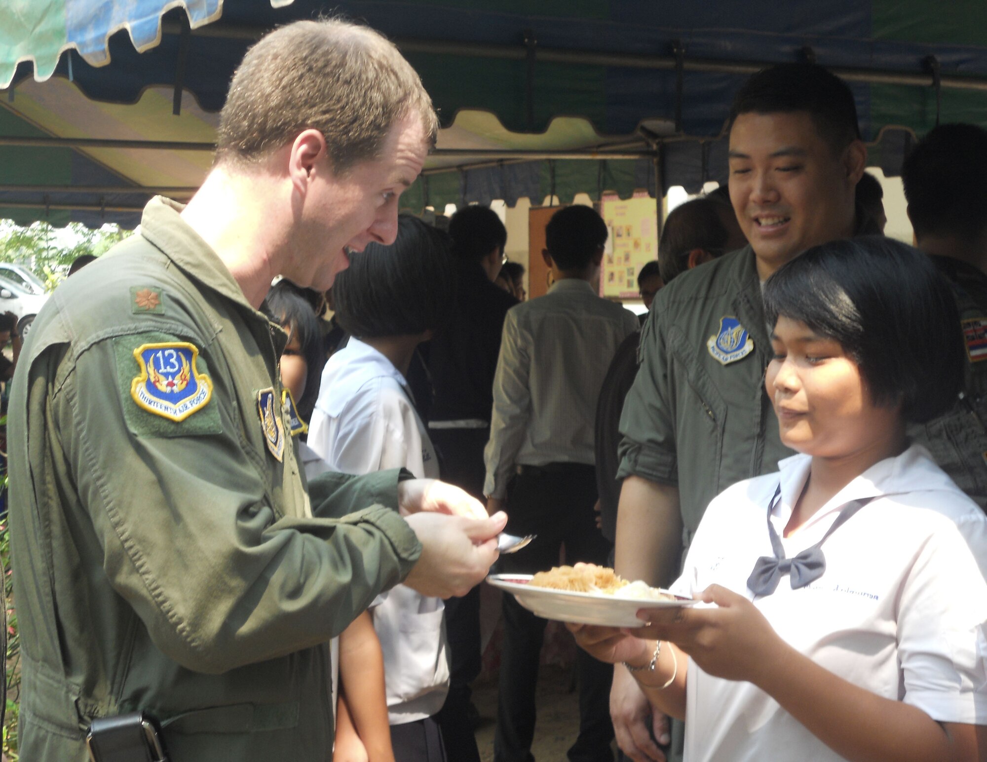 Maj. Greg Richert is served noodles March 14, 2011, by a student from Ang Huay Yang School in Korat, Thailand. Airmen visited the school with members of the Royal Thai and Republic of Singapore air forces during Cope Tiger 2011, an annual, multilateral, joint field training exercise being conducted in Thailand March 14 through 25. Major Richert is the chief of aerospace medicine at 13th Air Force, Joint Base Pearl Harbor-Hickam, Hawaii, and the medical lead for Exercise Cope Tiger 2011. (U.S. Air Force photo/Capt. Kirsten Udd) 