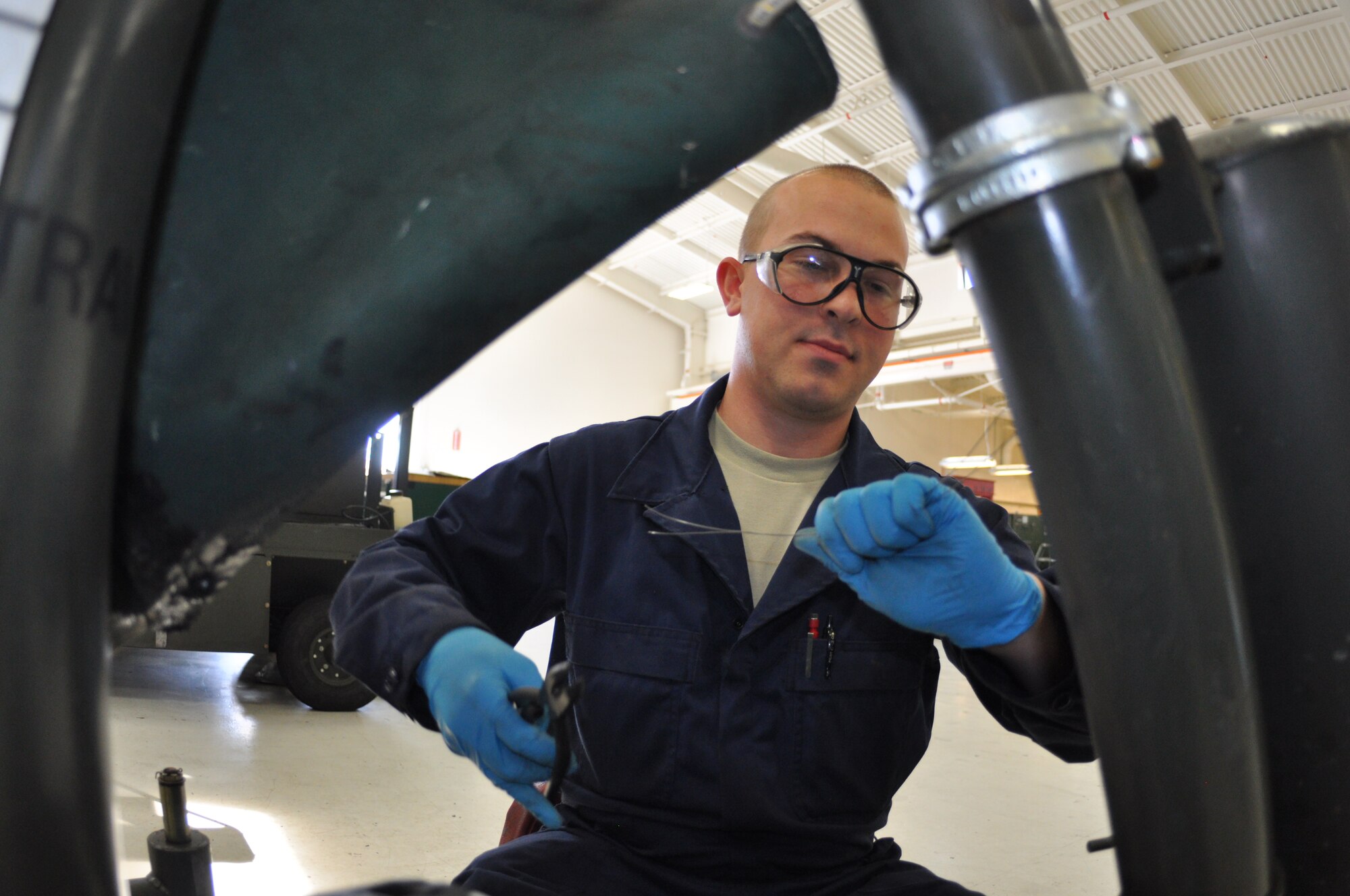 Airman 1st Class David Carnes, 60th Maintenance Squadron aerospace ground equipment apprentice, safety wires on an aircraft jack in the Inspection and Repair section of Aerospace Ground Equipment shop Mar 7.