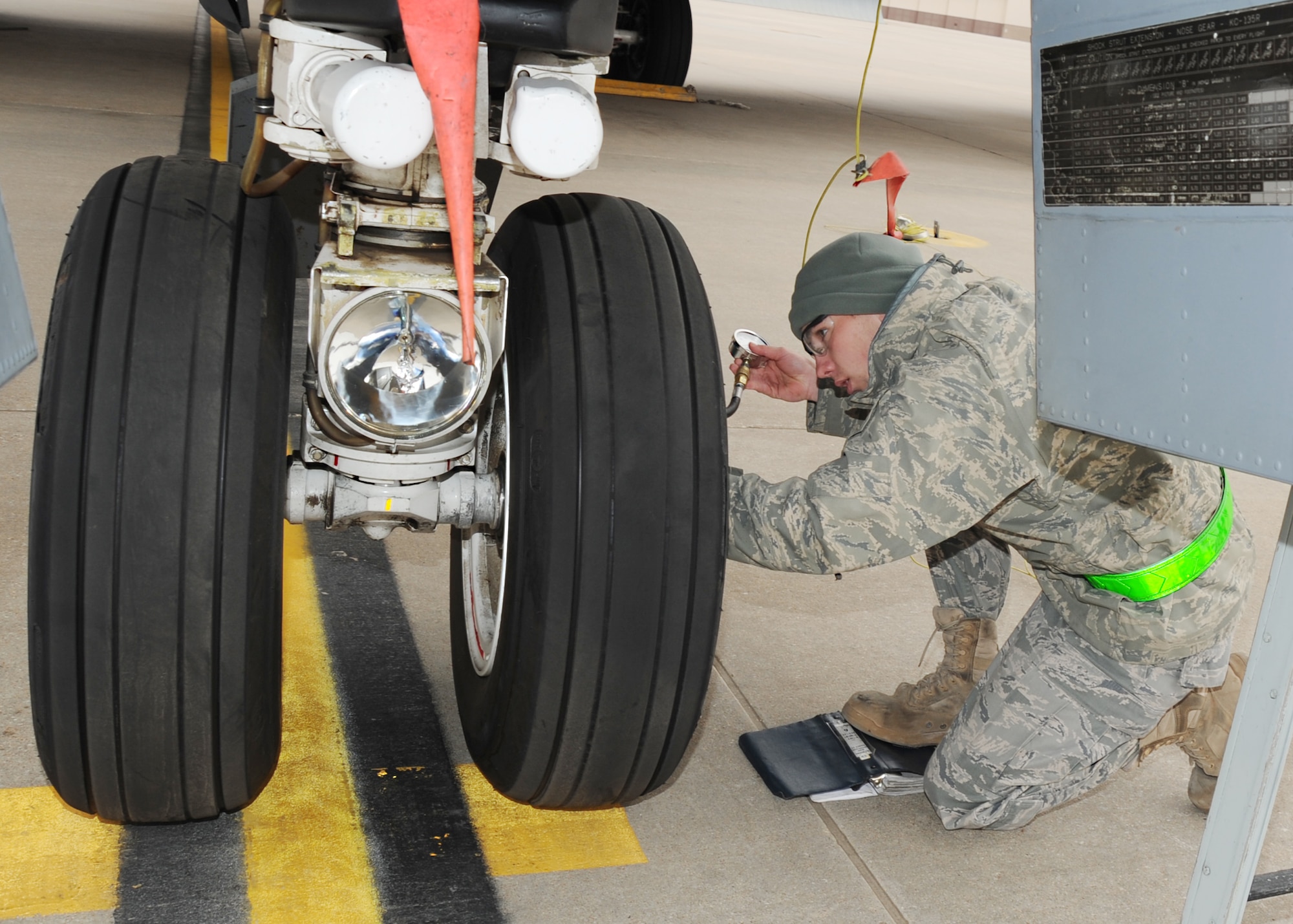 Airman 1st Class Kyle Outhouse, 22nd Aircraft Maintenance Squadron crew chief, measures the tire pressure of a KC-135 Stratotanker during a readiness exercise, March 9, 2011, McConnell Air Force Base, Kan. After inspection, the Stratotankers were towed to a different location, simulating an emergency mission. (U.S. Air Force photo/Senior Airman Maria A. Ruiz)