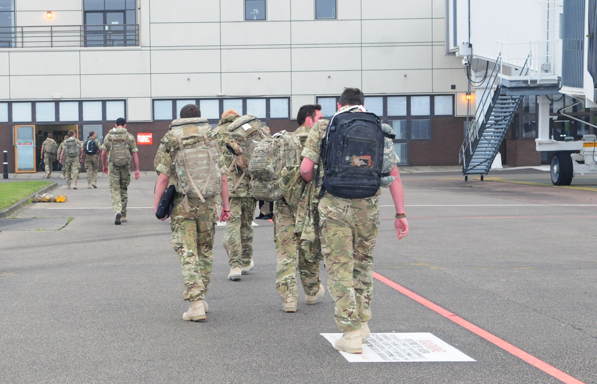 RAF MILDENHALL, England -- Members from 15 Squadron Royal Air Force Regiment enter the passenger terminal here before boarding a bus to their home station at nearby RAF Honington March 15, 2011. The British squadron returned from a four-month deployment in Afghanistan. (U.S. Air Force photo/Karen Abeyasekere)