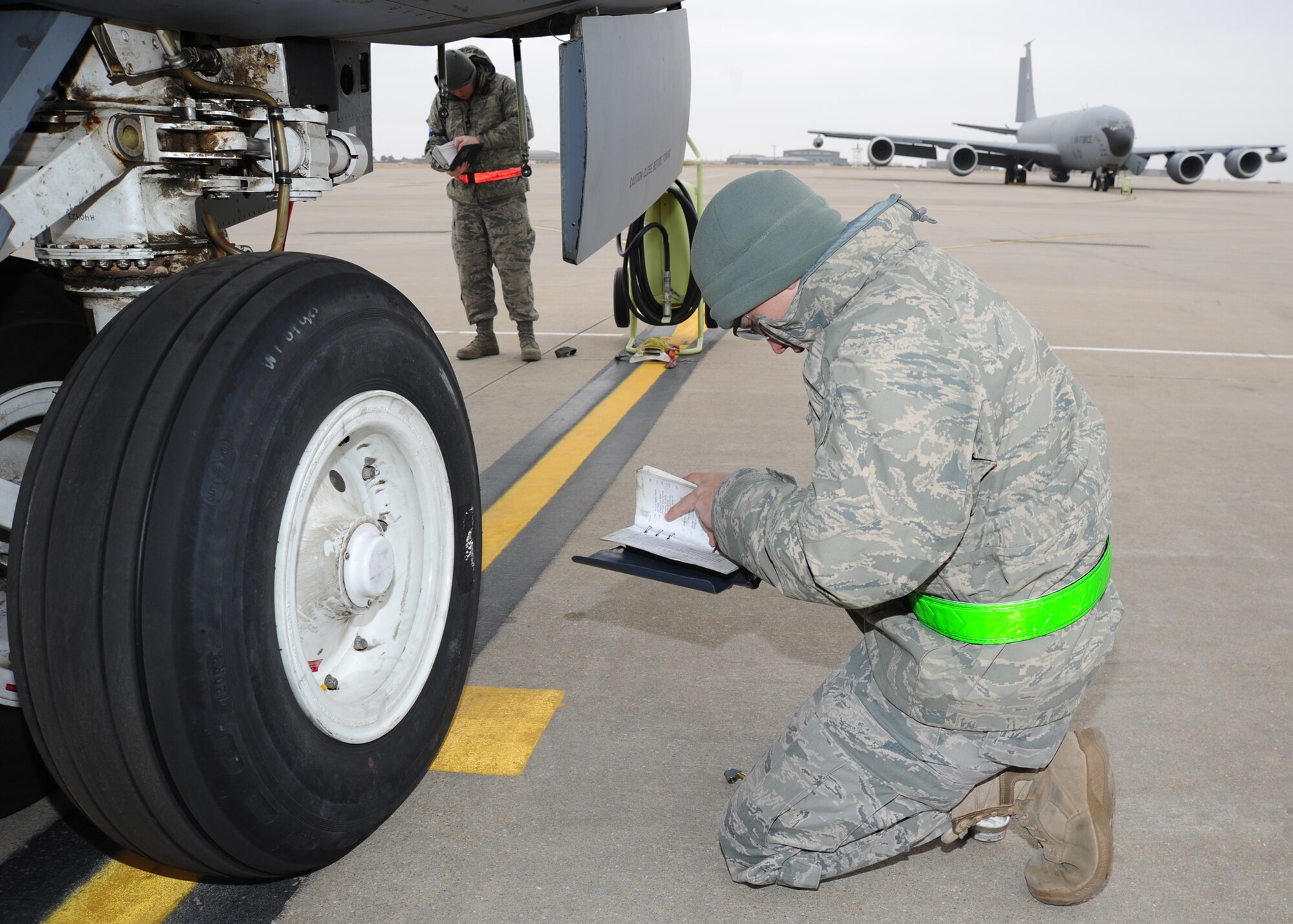 Airman 1st Class Kyle Outhouse, 22nd Aircraft Maintenance Squadron crew chief, and Senior Airman Bobby Hughes, 22nd Maintenance Squadron crew chief, review the technical orders of a KC-135 Stratotanker during a readiness exercise, March 9, 2011, McConnell Air Force Base, Kan. The NORE prepared aircrew and maintenance Airmen for a short notice mission evacuation. (U.S. Air Force photo/Senior Airman Maria A. Ruiz)