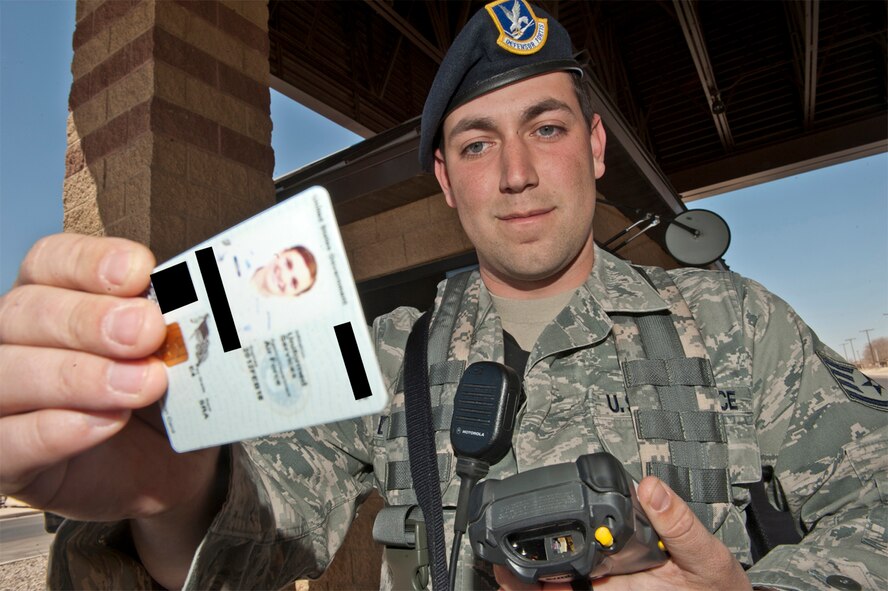 HOLLOMAN AIR FORCE BASE, N.M. -- Staff Sgt. Matthew Dodson, 49th Security Forces Squadron, uses a Defense Biometric Identification System to check a government ID card, March 15, 2011, before allowing a member of Team Holloman to enter the base at the main gate. Entry-controllers work in conjunction with personnel manning the Welcome Center to identify people with outstanding warrants and prevent them from entering the base. (U.S. Air Force photo illustration by Senior Airman Veronica Stamps/Released)