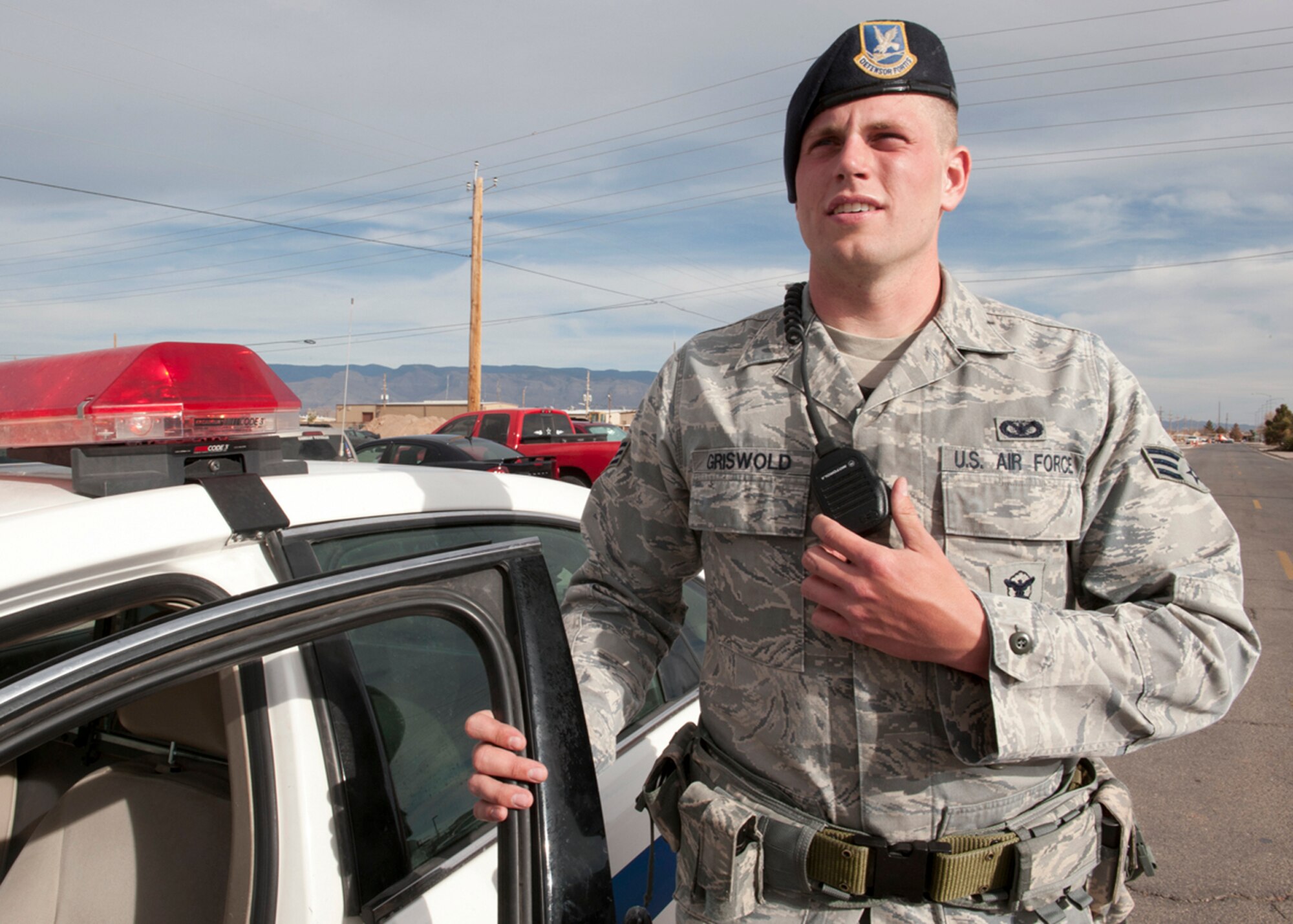 HOLLOMAN AIR FORCE BASE, N.M. -- Senior Airman Timothy Griswold, 49th Security Forces Squadron, poses next to a patrol car, March 6, 2011, while using his land mobile radio to simulate a call-in. Members of the 49th SFS patrol the base and protect the flightline. They also provide the base’s outer layer of protection by manning all entry gates. (U.S. Air Force photo by Senior Airman Veronica Stamps/Released)
