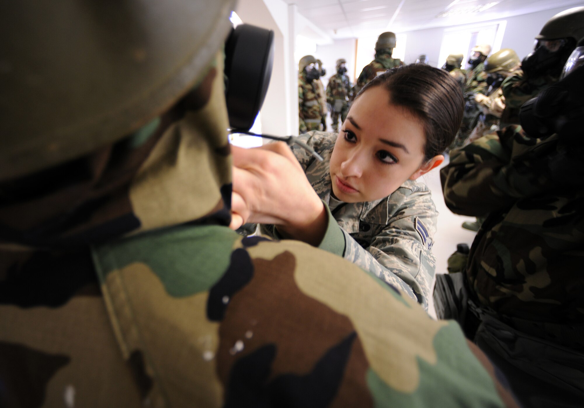 SPANGDAHLEM AIR BASE, Germany – Airman 1st Class Samantha Green, 52nd Civil Engineer Squadron Chemical, Biological, Radiological, Nuclear and Explosives Survival Skills Training instructor, corrects an Airman’s protective gear during CBRNE Survival Skills Training March 15. Instructors provide Airmen with hands-on training to prepare them for overseas contingency operations. (U.S. Air Force photo/Senior Airman Nathanael Callon)