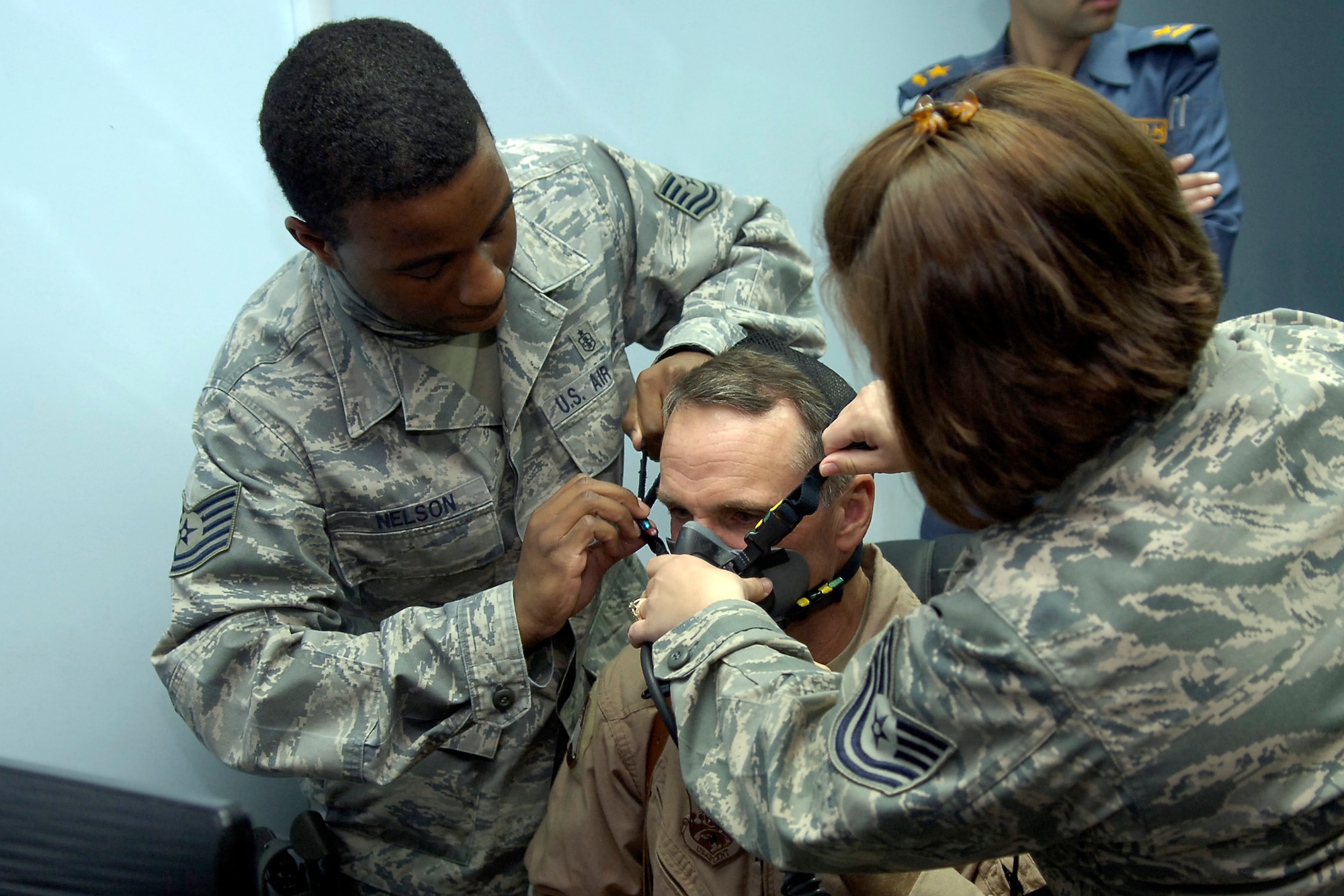 NEW AL-MUTHANA AIR BASE, Iraq – Tech. Sgt. Pierre Nelson, U.S. Air Force Global Strike Command aerospace operational physiology technician, tightens the straps on the face mask for Brig. Gen. Anthony Rock, 321st Air Expeditionary Wing commander and Iraq Training and Advisory Mission-Air director, as part of a demonstration of the Iraqi Air Force’s first Reduced Oxygen Breathing Device here March 14. Sergeant Nelson, is deployed from Barksdale Air Force Base, La., to teach the IqAF how to use the device which is designed to take the place of the altitude chamber for pilot refresher training. (U.S. Air Force photo by Tech. Sgt. Randy Redman)