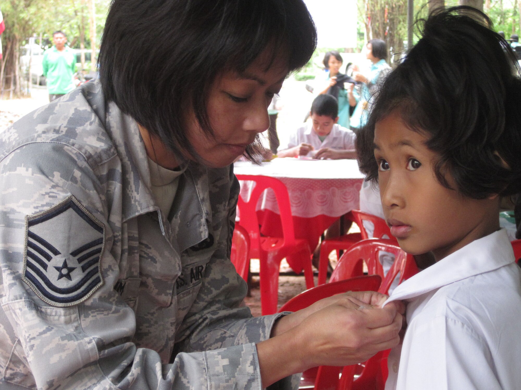 KORAT, Thailand - Master Sgt Chris Lim, Communications and Information Supervisor for Cope Tiger 2011, pins a U.S. Air Force commemorative pin on the lapel of a student from the Ang Huai Yang School during a community outreach event in Korat, Thailand, March 16. Lim is one of more than 700 servicemembers participating in Exercise Cope Tiger 2011, an annual, multilateral, joint field training exercise currently being conducted at Korat and Udon Thani Royal Thai Air Bases March 14 through 25. (U.S. Air Force Photo/ Capt. Kirsten Udd)