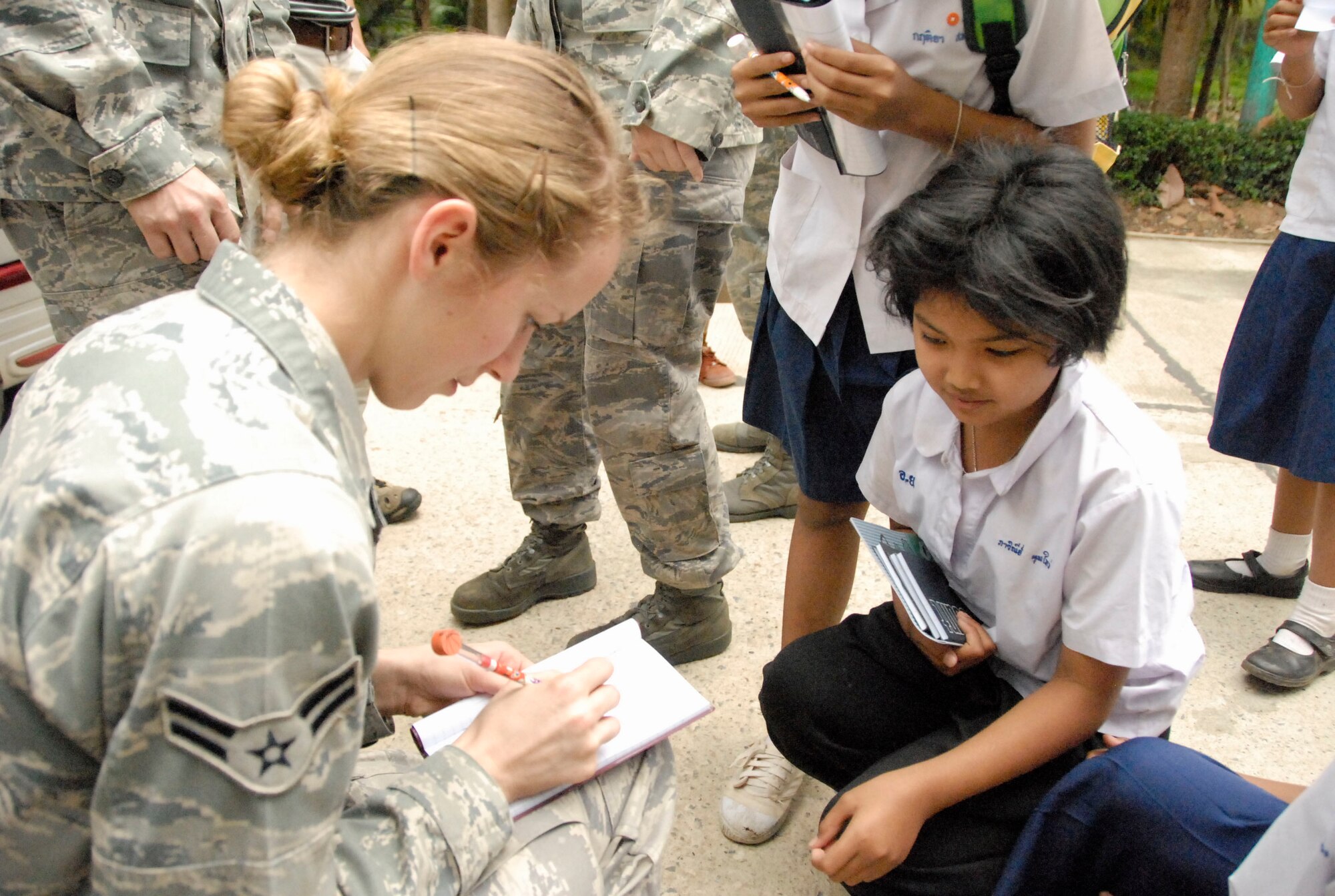 KORAT, Thailand - Airman 1st Class Stephanie Rogge signs autographs for children from the Ang Huai Yang School during a community outreach event in Korat, Thailand, March 16. Airman Rogge is a munitions airman with the 44th Air Expeditionary Fighter Squadron, deployed from Kadena Air Base, Japan, in support of Cope Tiger 2011, an annual, multilateral, joint field training exercise currently being conducted at Korat and Udon Thani Royal Thai Air Bases March 14 through 25. (U.S. Air Force Photo/ Capt. David Herndon)
