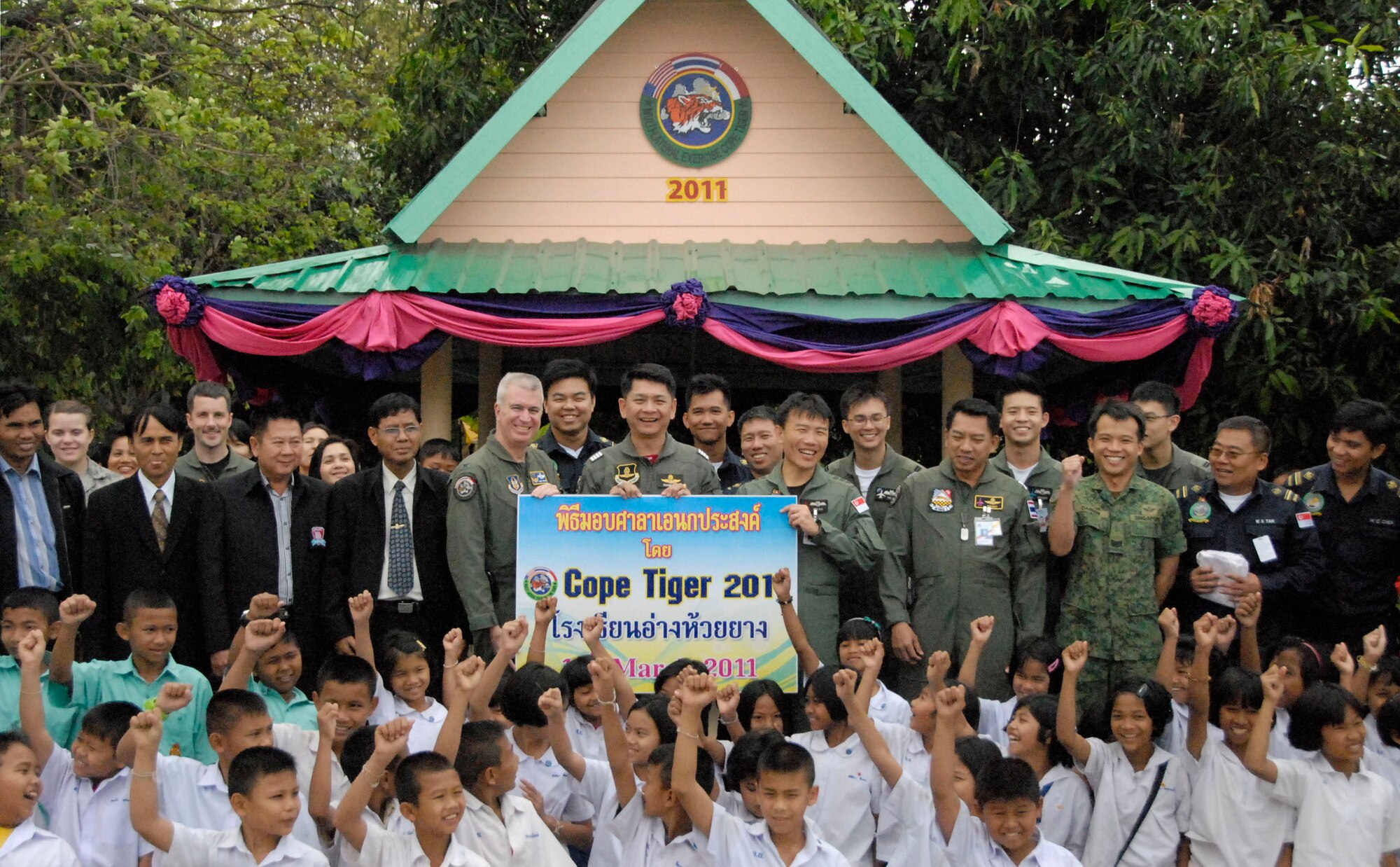 KORAT, Thailand - Servicemembers from the U.S., Republic of Singapore, and Royal Thai Air Forces celebrate the opening of a newly-renovated school bus stop with students and teachers at the Ang Huai Yang School at in Korat, Thailand, March 16. Community outreach events are part of Exercise Cope Tiger 2011, an annual, multilateral, joint field training exercise currently being conducted at Korat and Udon Thani Royal Thai Air Bases March 14 through 25. (U.S. Air Force Photo/ Capt. David Herndon)