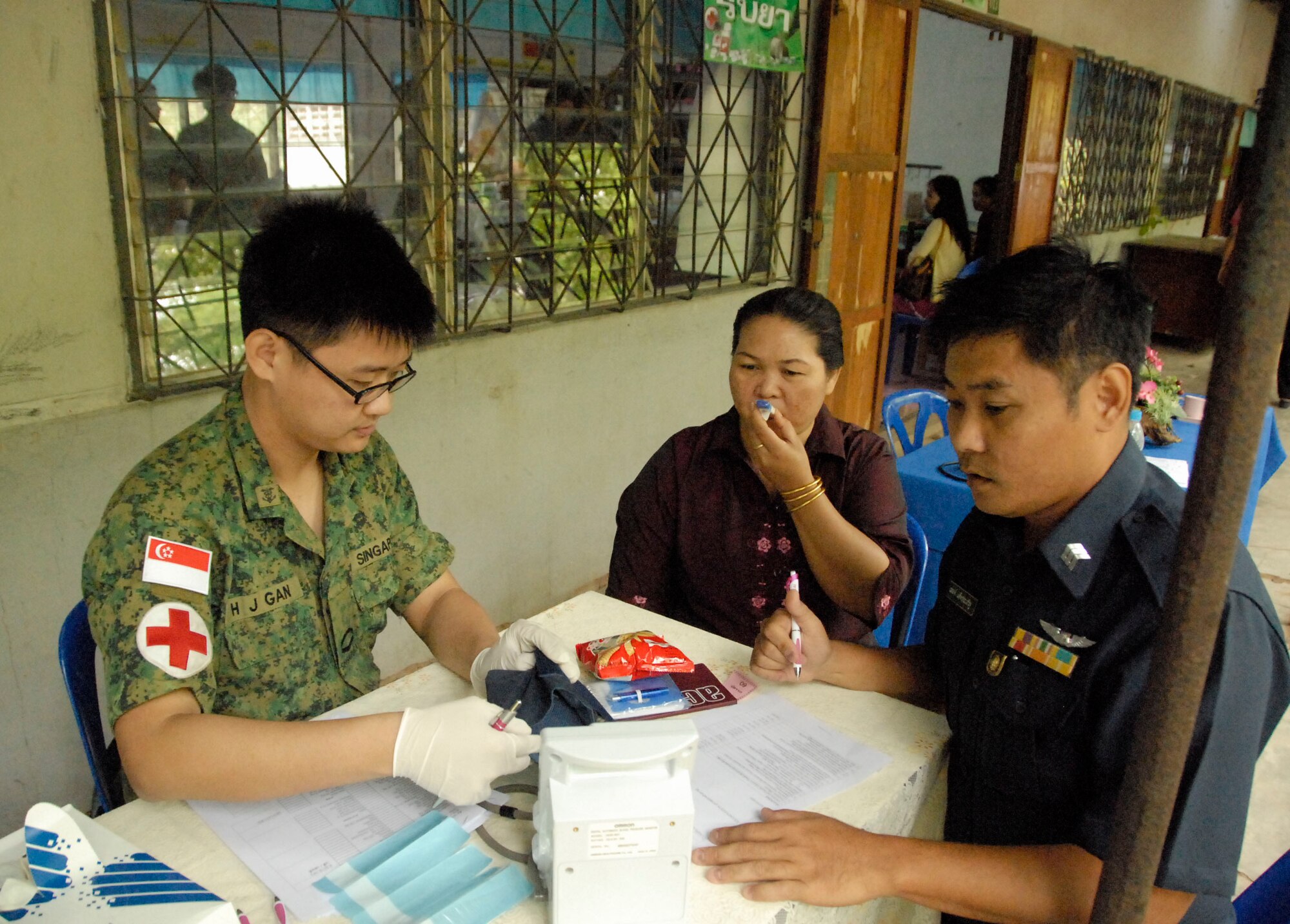 KORAT, Thailand - Servicemembers from the Republic of Singapore Air Force provide medical care to the community during a community outreach event at the Ang Huai Yang School in Korat, Thailand, March 16. Servicemembers from the U.S., Republic of Singapore, and Royal Thai Air Forces participated in the event while supporting Cope Tiger 2011, an annual, multilateral, joint field training exercise currently being conducted at Korat and Udon Thani Royal Thai Air Bases March 14 through 25. (U.S. Air Force Photo/ Capt. David Herndon)