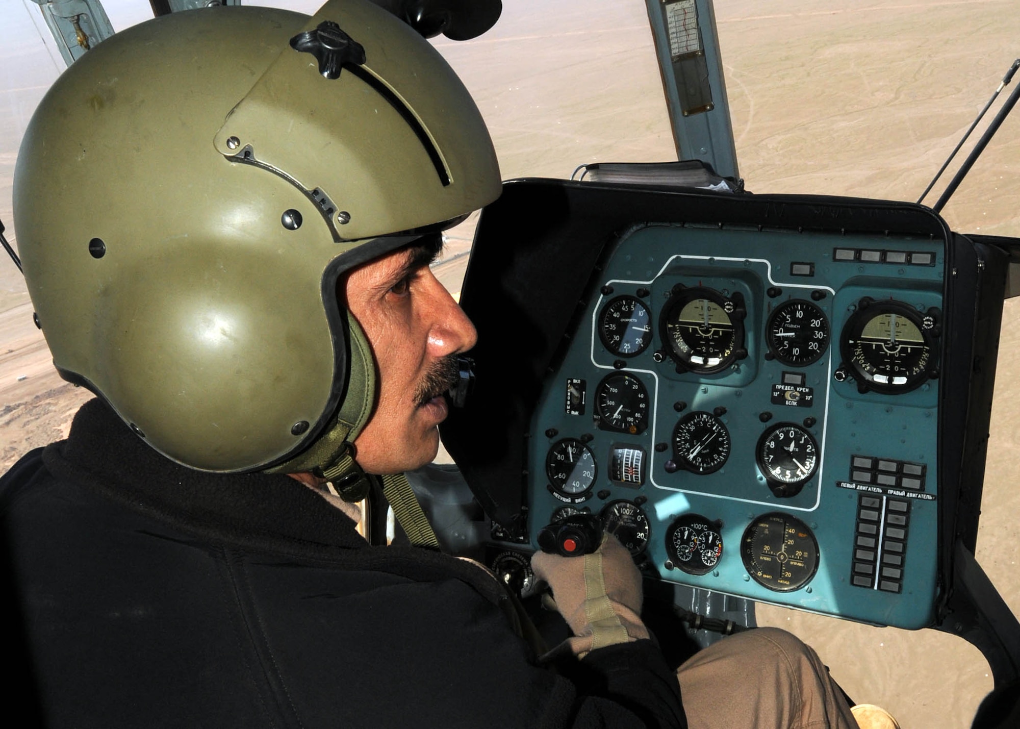 SHINDAND, Afghanistan - Afghan Air Force Capt. Qiyamiddin, a Mi-17 transport helicopter student pilot, practices flying procedures at the AAF training center in Shindand, Afghanistan. This was the first time that an AAF instructor pilot served as chief instructor for an Afghan pilot. (U.S. Navy photo by Mass Communications Specialist 3rd Class Jared E. Walker)