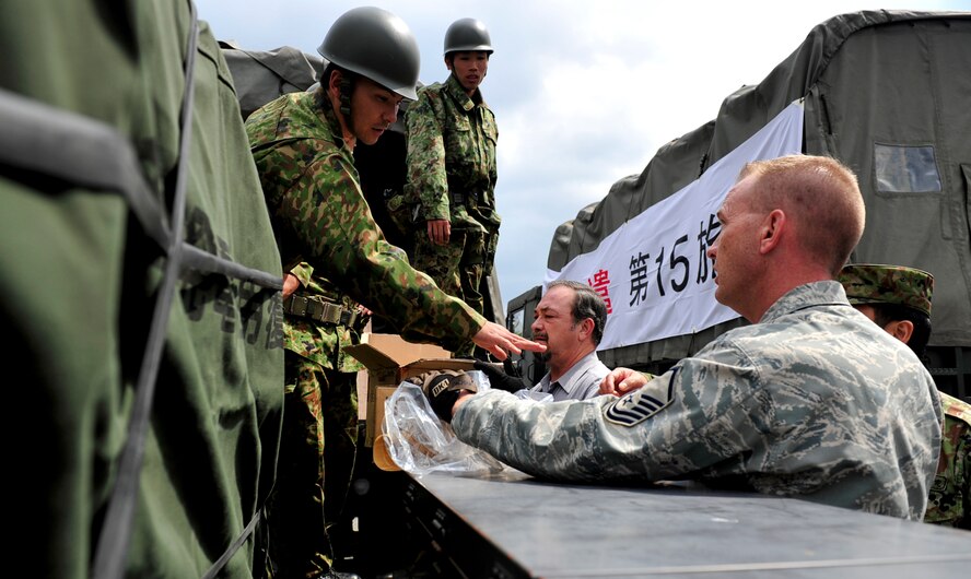 Master Sgt. Randall Dechant, the deployment and distribution flight superintendant with the 18th Logistics Readiness Squadron, works with members of the 15 Brigade, Japan Ground Self Defense Force to load and prepare supplies on trucks headed to mainland Japan March 16. Teams from the 15 Brigade, JGSDF are heading to northern Japan to aid earthquake and tsunami victims with trucks loaded with supplies including clothes, blankets and toiletries. (U.S. Air Force photos/Senior Airman Sara Csurilla)