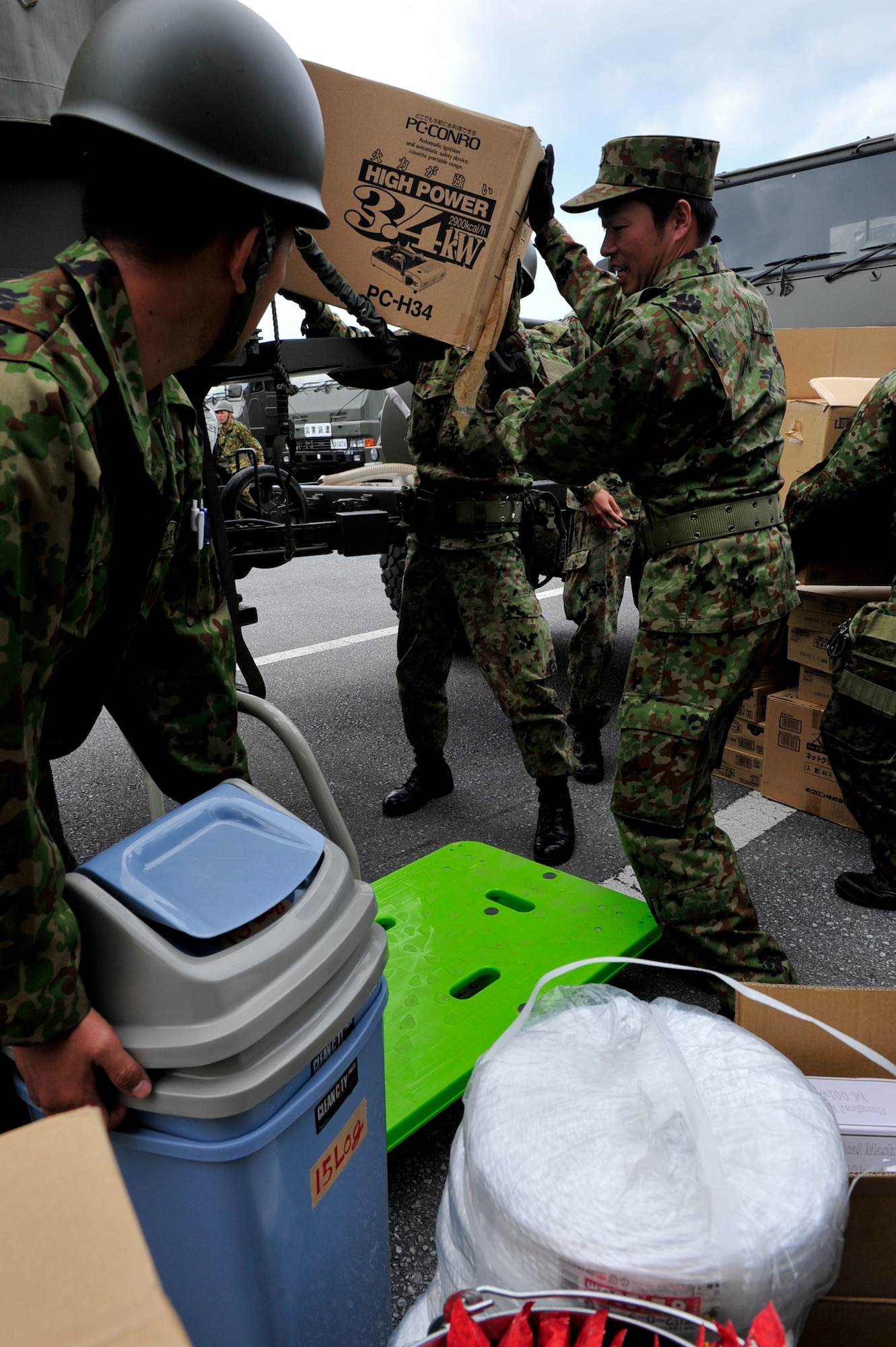 Members of the 15 Brigade, Japan Ground Self Defense Force load and prepare supplies on trucks headed to mainland Japan March 16. Teams from the 15 Brigade, JGSDF along with thousands of pounds of supplies are heading to northern Japan to aid earthquake and tsunami victims. (U.S. Air Force photos/Senior Airman Sara Csurilla)
