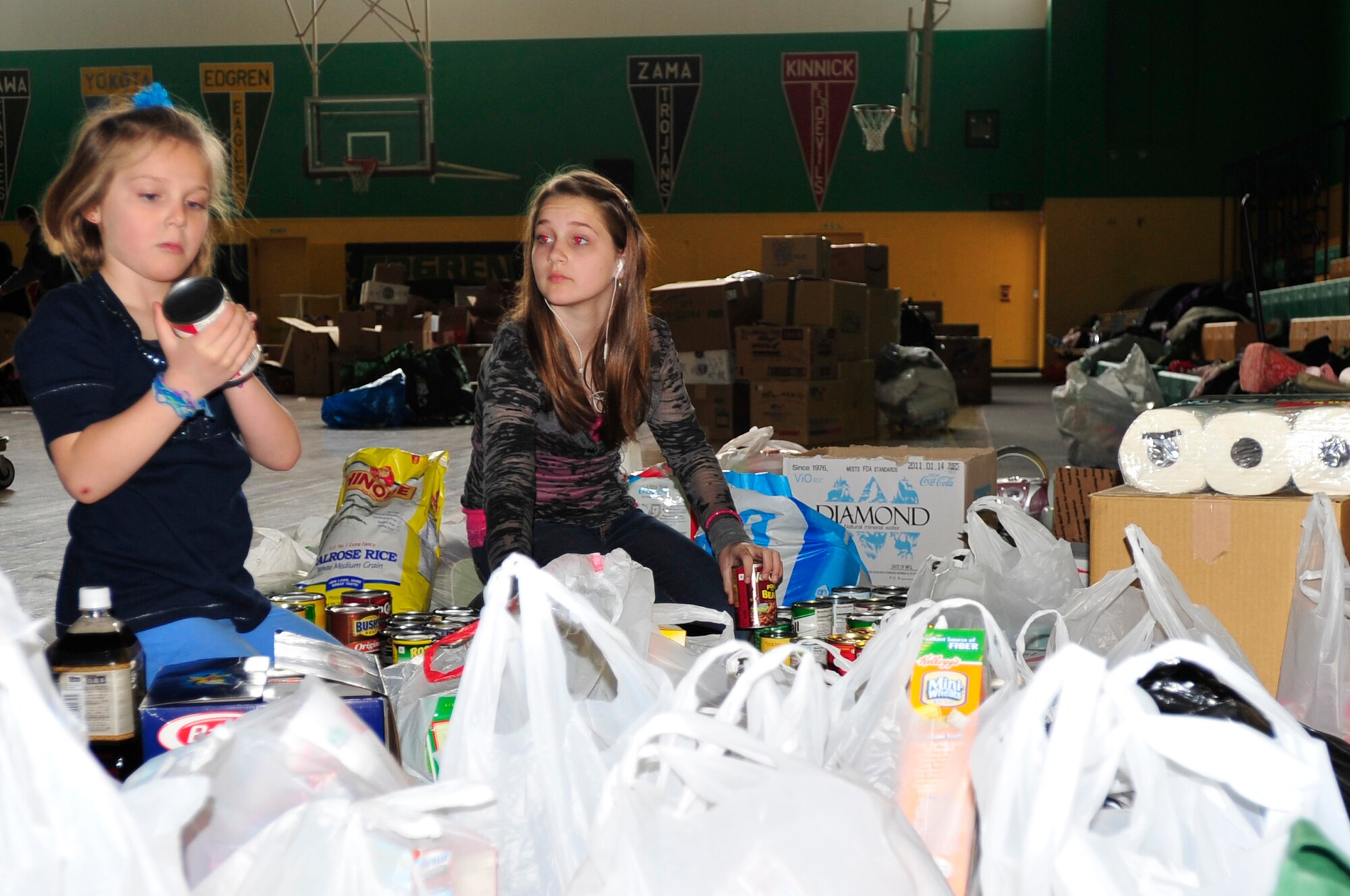 MISAWA AIR BASE, Japan -- Brogan and Emerson Retka, sort through bags and boxes of food Mar. 15. Residents answered the call for help by donating clothes, jackets, blankets and food to help out Japanese residents affected by last Friday's earthquake and tsunamis. (U.S. Air Force photo by Staff Sgt. Marie Brown\Released)