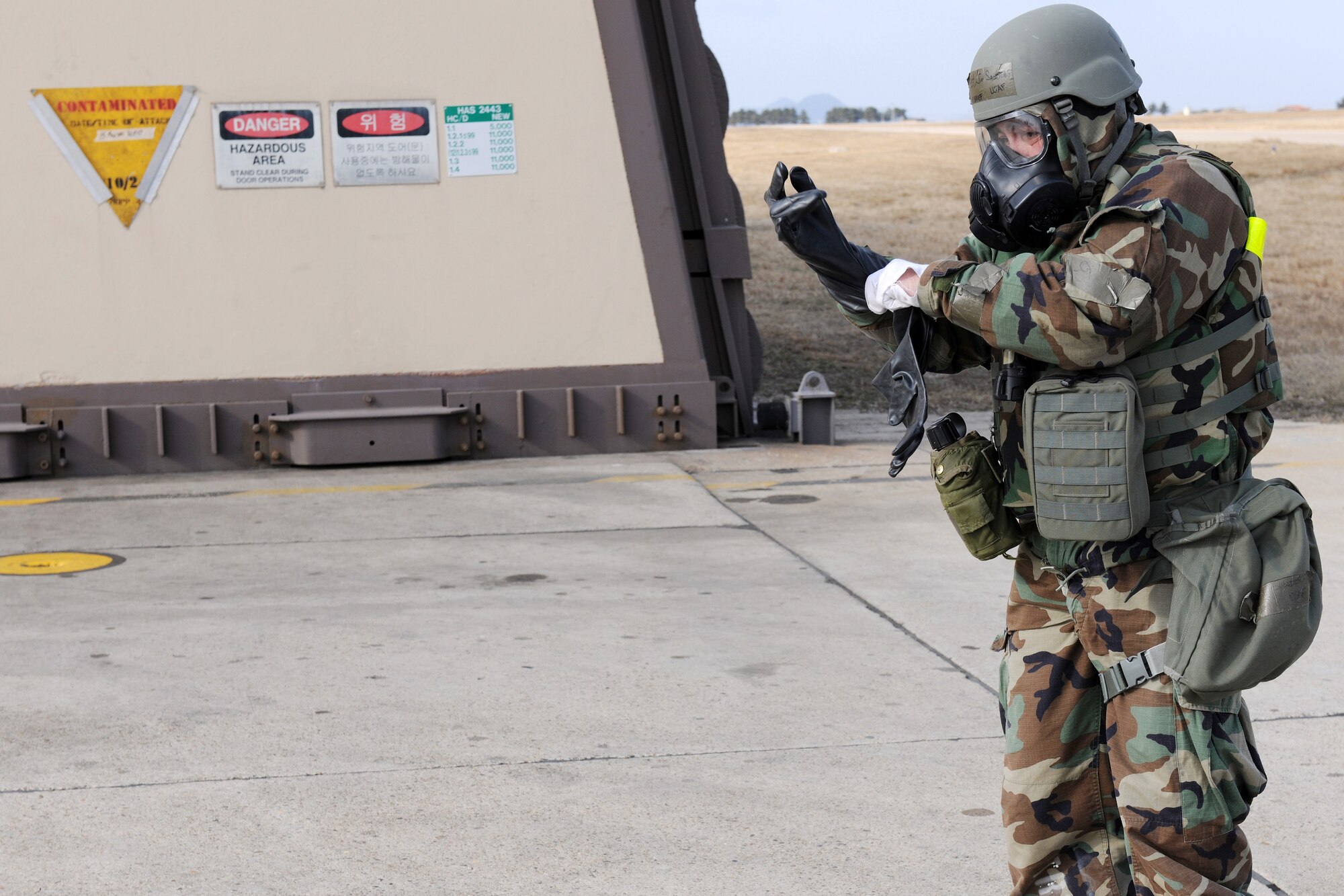 KUNSAN AIR BASE, Republic of Korea -- Chief Master Sgt James Sanders, 8th Fighter Wing command chief, dons protective gear before approaching a simulated contaminated building during exercise Beverly Midnight 11-02 March 16. When approaching contaminated facilities or equipment during the initial phase, don MOPP 4 before approaching within 10 feet of the object. (U.S. Air Force photo/Tech. Sgt. Jonathan Pomeroy) 
