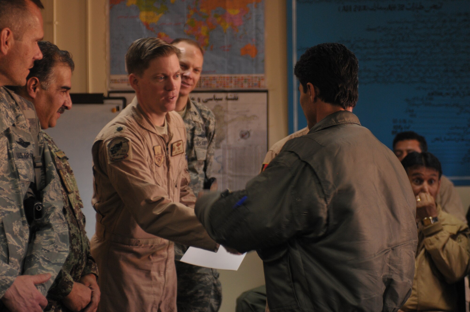 KABUL, Afghanistan -   An Afghan Air Force pilot receives his certificate for completing an aviation English language course at the AAF Base in Kabul March 14. The course, split between varying levels of language proficiency ranging from elementary to intermediate, taught aviation-centric English meant to help the airmanship of Afghan pilots and was sponsored by the British Council, a U.K. based organization specializing in international education and cultural opportunities. (U.S. Navy photo by Mass Communications Specialist 2nd Class Vladimir Potapenko) 