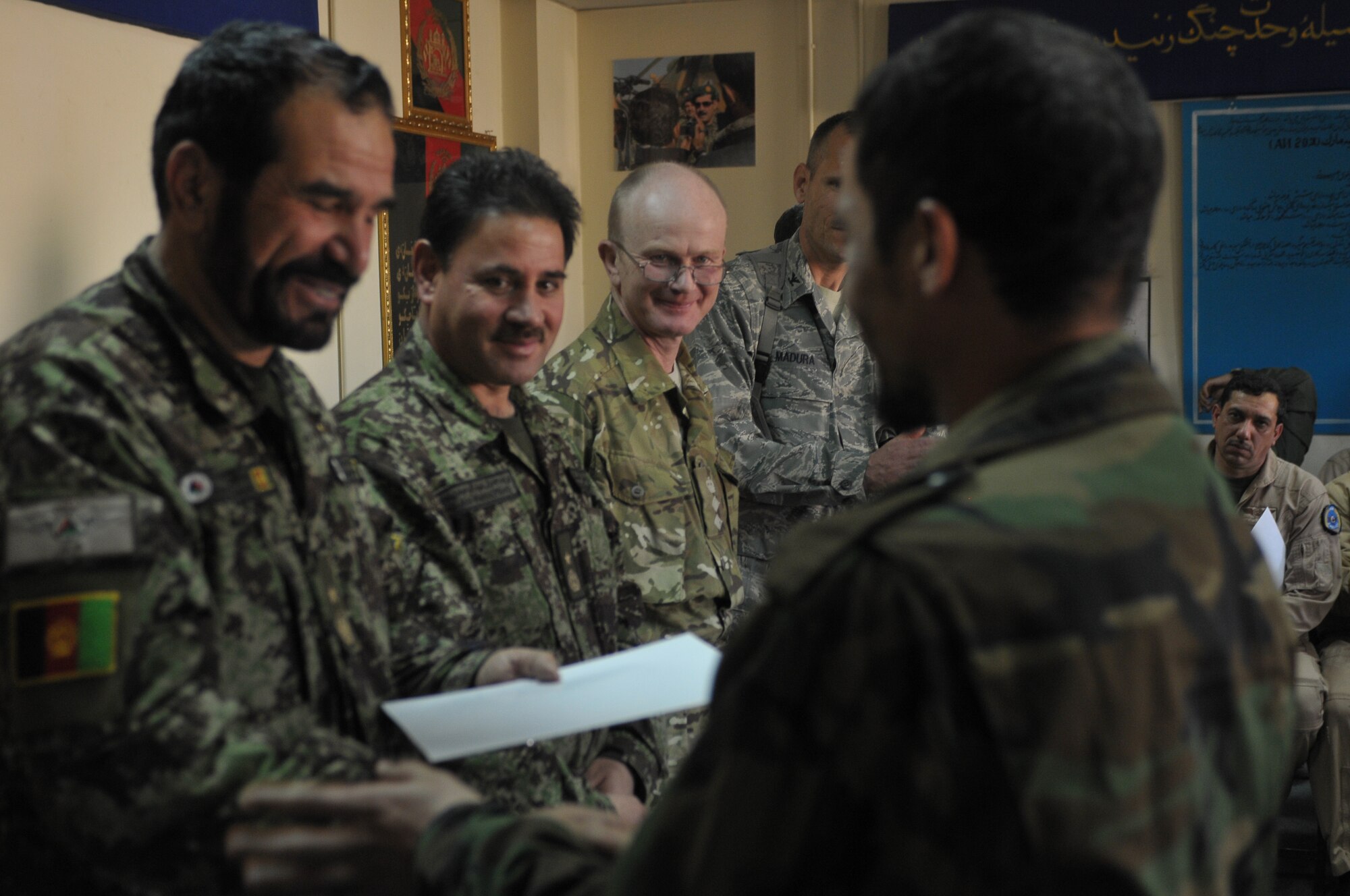 KABUL, Afghanistan -   An Afghan Air Force pilot receives his certificate for completing an aviation English language course at the AAF Base in Kabul March 14. The course, split between varying levels of language proficiency ranging from elementary to intermediate, taught aviation-centric English meant to help the airmanship of Afghan pilots and was sponsored by the British Council, a U.K. based organization specializing in international education and cultural opportunities. (U.S. Navy photo by Mass Communications Specialist 2nd Class Vladimir Potapenko) 