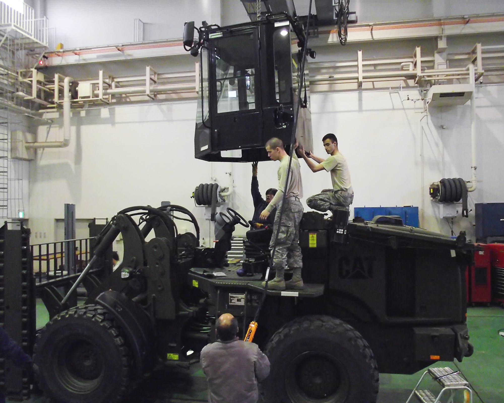 YOKOTA AIR BASE, Japan -- Members from the 374th Logistics Readiness Squadron's vehicle management flight remove the operator's cab from a CAT 10K All Terrain forklift in preparation for an air shipment to assist the earthquake and tsunami recovery efforts here March 16. Two forklifts and two HUMMWV were prepared for the 353rd Special Tactical Squadron from Kadena Air Base, Japan, in support of Operation Tomodachi. (U.S. Air Force photo/Tech. Sgt. John Souza)