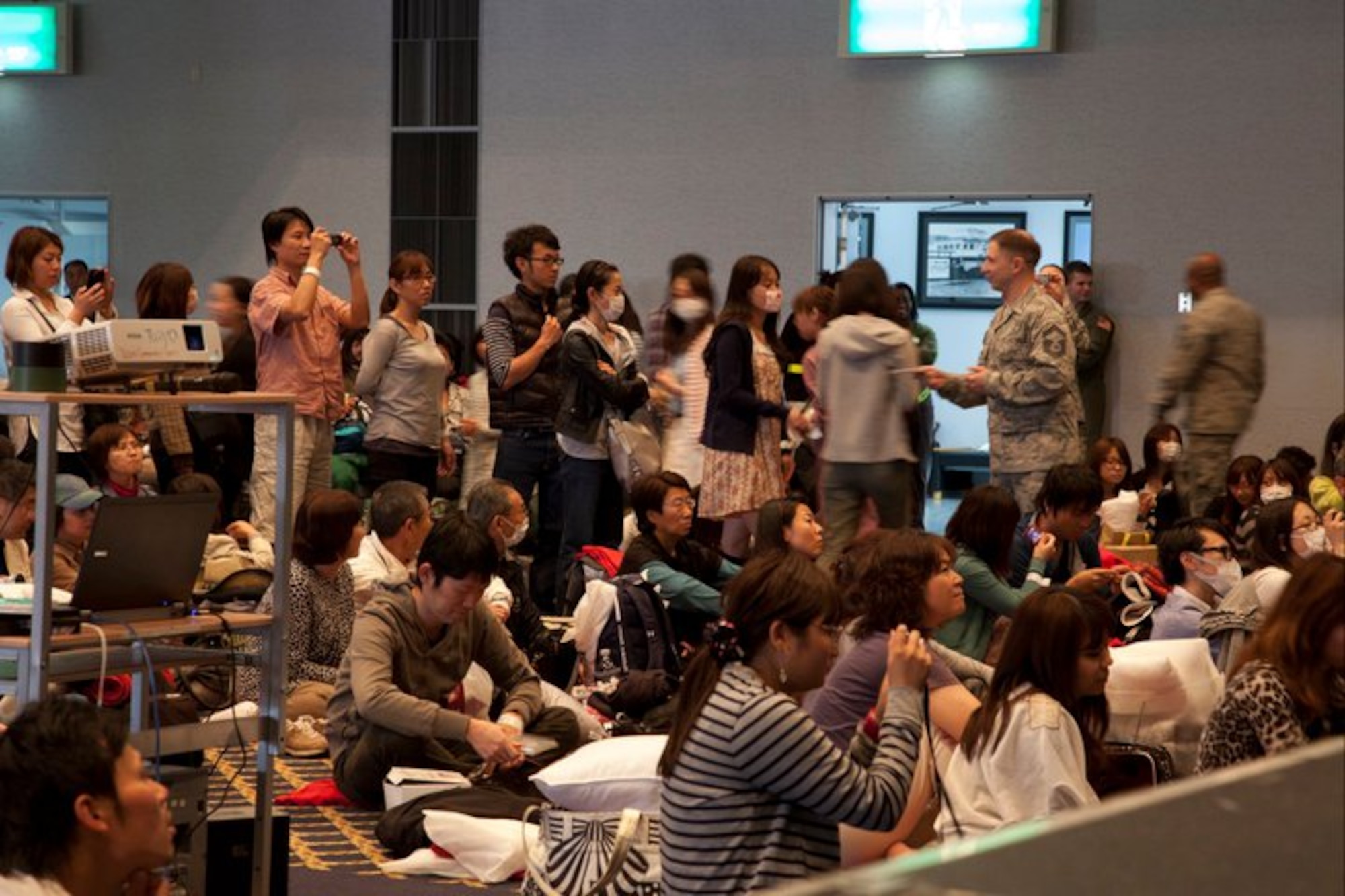 Passengers stand in line and snap pictures while the Band of Pacific-Asia
Jazz Combo performs. SMSgt Michael Goetz shakes hands and passes out free
copies of the band's "Friendship" CD. (Courtesy photo)

