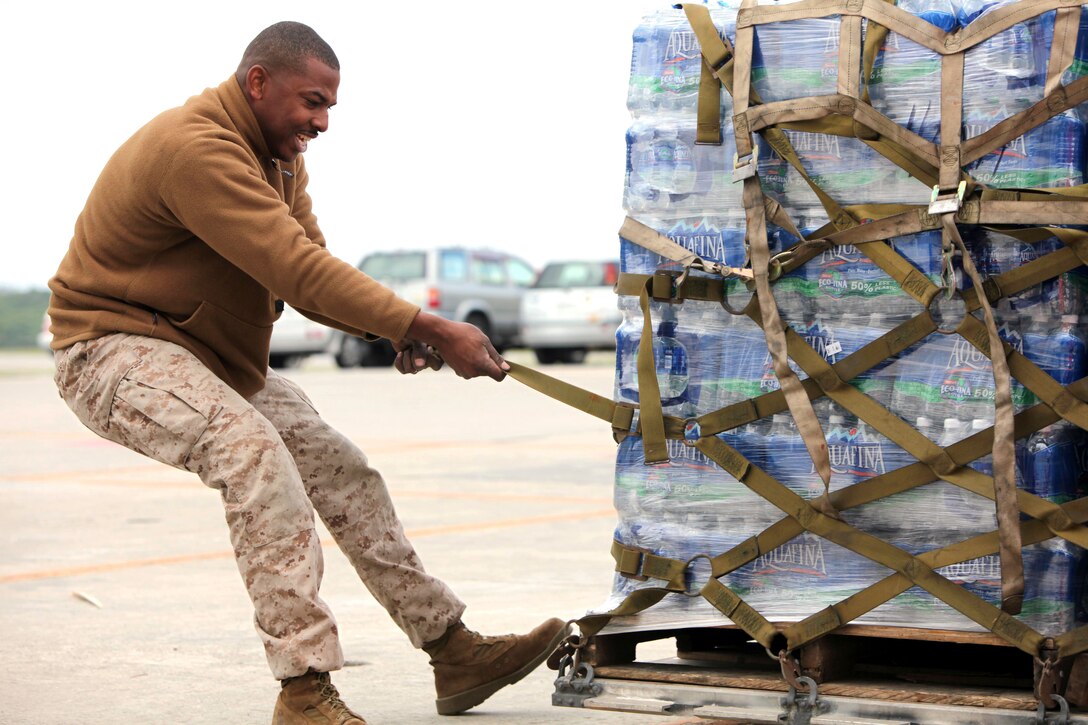 U.S. Marine Corps Sgt. John Smith tightens a strap to secure relief supplies on Marine Corps Air Station Futenma, Japan, March 16, 2011. The Marines are assigned to the 3rd Marine Expeditionary Force’s Combat Logistics Regiment 37, 3rd Marine Logistics Group. They are helping to deliver more than 140 cases of bottled water and other aid to residents on mainland Japan as part of Operation Tomodachi following the recent earthquake and tsunami. 