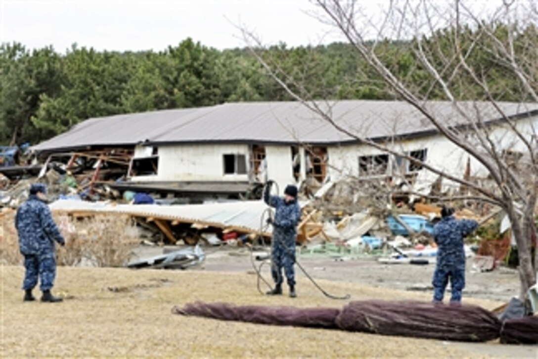 U.S. Navy sailors remove debris from a park at the fishing port in Misawa, Japan, on March 15, 2011.  More than 120 sailors and airmen from Naval Air Facility Misawa are assisting Misawa city workers and residents in relief efforts.  