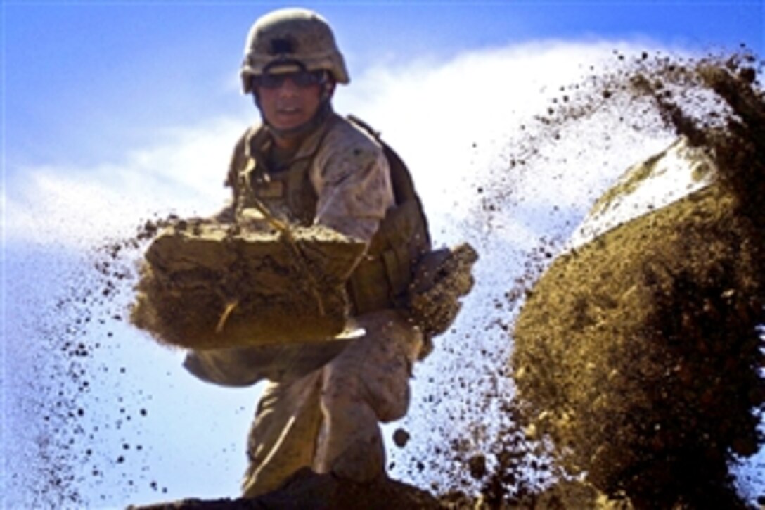 U.S. Marine Corps Lance Cpl. Marvin Lopez shovels dirt during a bridge construction project in Haji Hanif Khan, Afghanistan, March 9, 2011. Lopez is a combat engineer assigned to Engineer Company, Combat Logistics Battalion 3, 2nd Marine Logistics Group. The company's engineers and heavy equipment operators have conducted several civil development and military construction projects throughout Afghanistan since they arrived in October. 