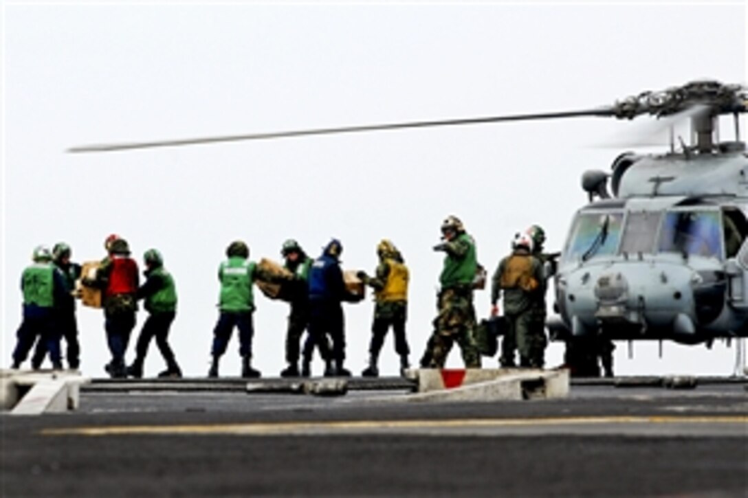 U.S. Navy sailors move food and water onto an HH-60H Seahawk helicopter aboard the aircraft carrier USS Ronald Reagan in the Pacific Ocean, March 15, 2011. The Ronald Reagan is off the coast of Japan providing humanitarian assistance in Japan to support Operation Tomodachi. The sailors are assigned to Anti-Submarine Squadron 4.