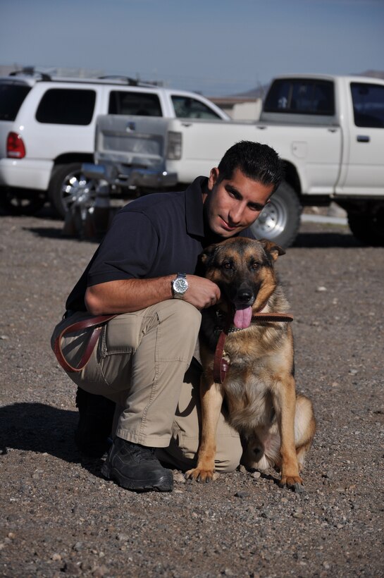 Marine Corps Police Department working dog handler Nadeem Seirafi kneels alongside his new crime-fighting partner, "Kit Kat," a 2-year-old German Shepherd, March 16 aboard Marine Corps Logistics Base Barstow. The 32-year-old Palm Springs, Calif., native and his four-legged sidekick were teamed together following his 11-week training course at the DOD Military Working Dog School at Lackland Air Force Base in San Antonio.